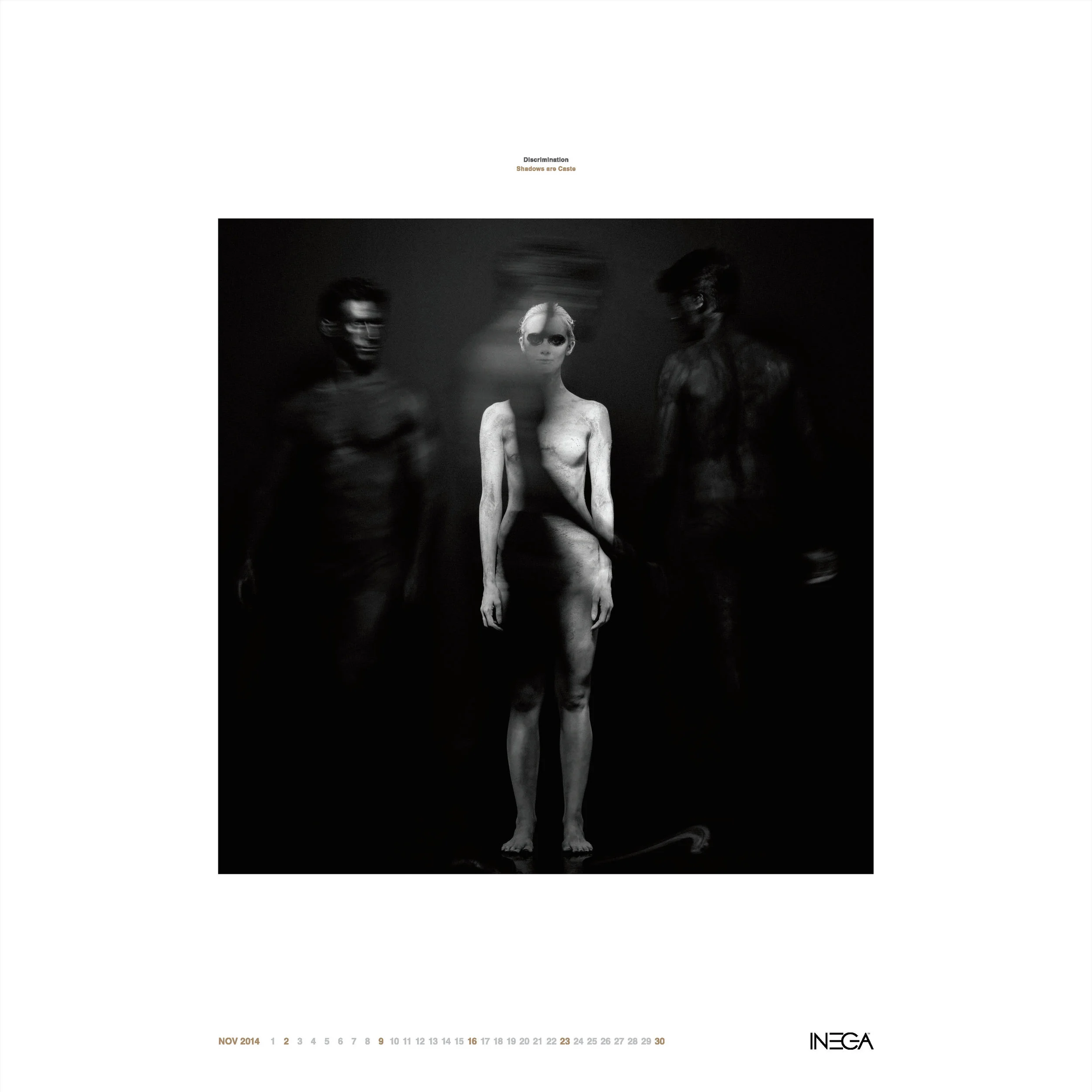 Black and white artistic photograph of three human-like figures; the central figure is a lithe, pale woman with short hair and sunglasses, flanked by two shadowy, less detailed figures. The image has a blurred and surreal appearance with a minimalist
