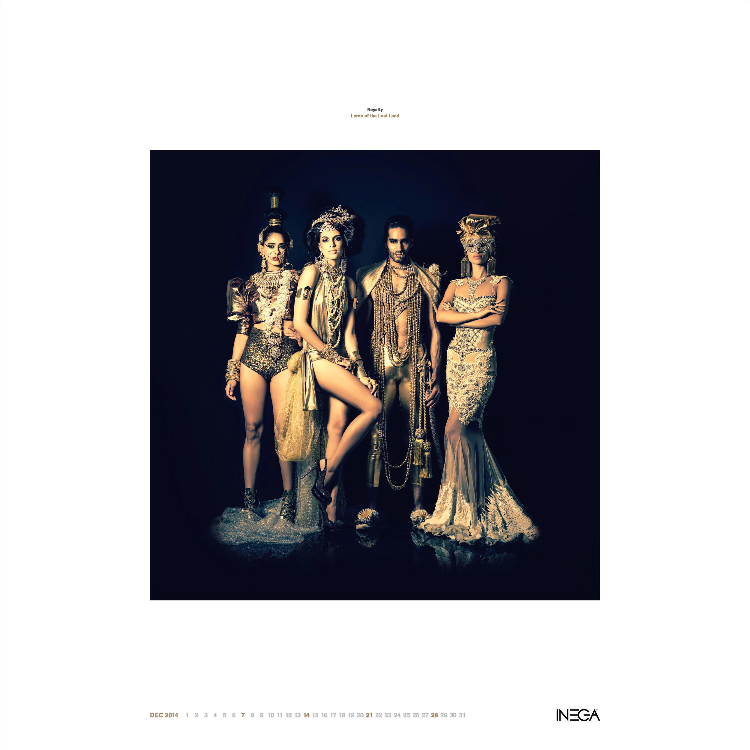 A group of four models dressed in elaborate, ornate costumes with gold and metallic accents, standing against a dark background.