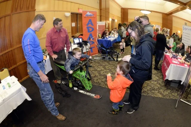 Don Hickman and Jim Bradley, ADAPT sports, demonstrate a ski chair to Sara Clippinger and children during the Special Needs Summit March 15, 2018, at Hill Air Force Base, Utah. The annual summit gives the base community a chance to research and learn about many speacial needs services and opportunities available in the area. (U.S. Air Force photo by Todd Cromar)
