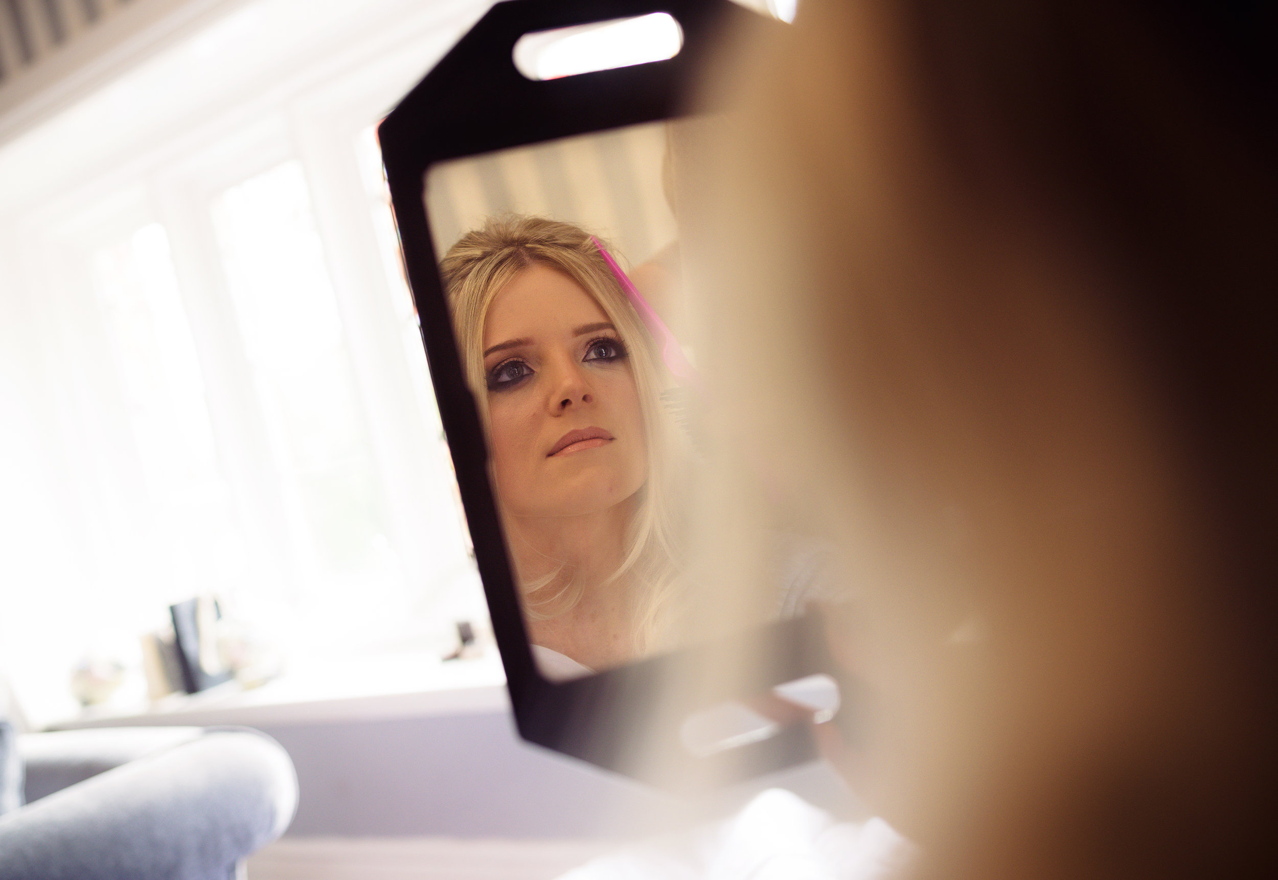 Bride looking into a mirror during makeup