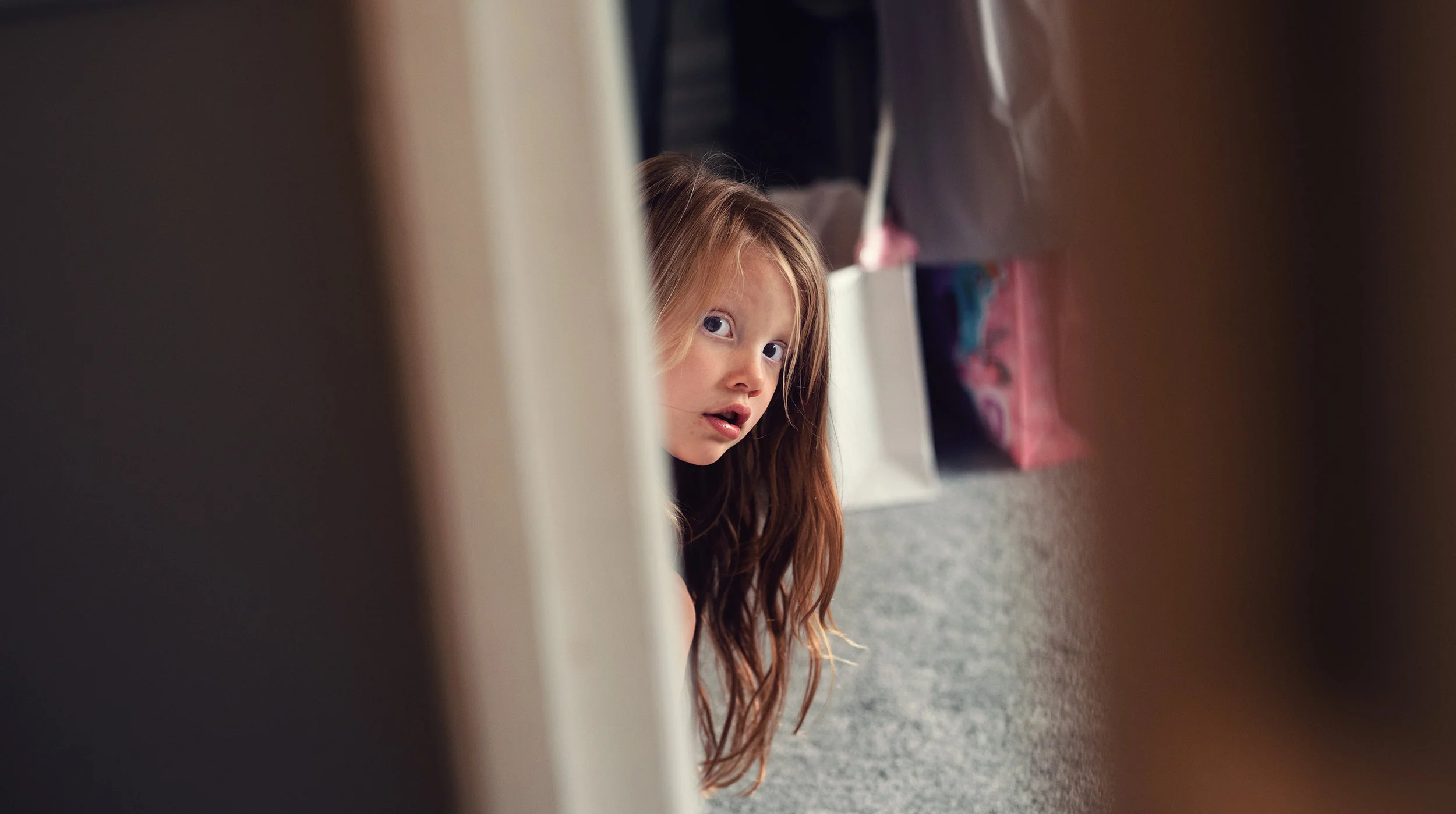 A bridesmaid peeping around a doorway
