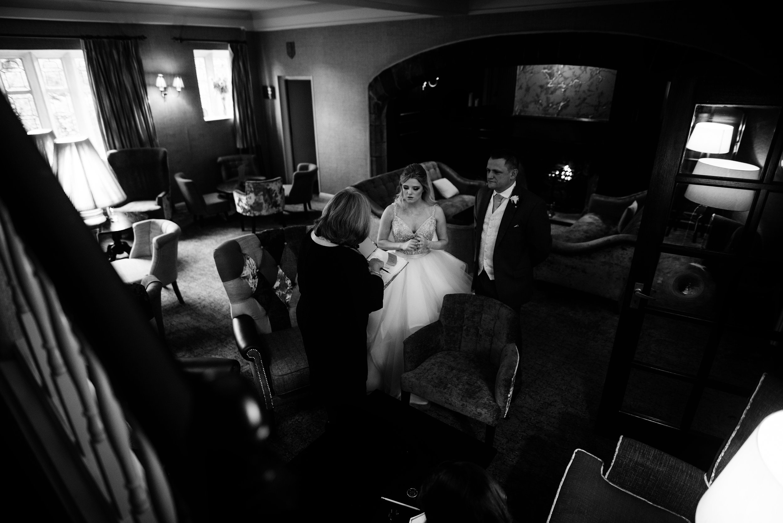 Black and white image of a very nervous bride talking to the registrar