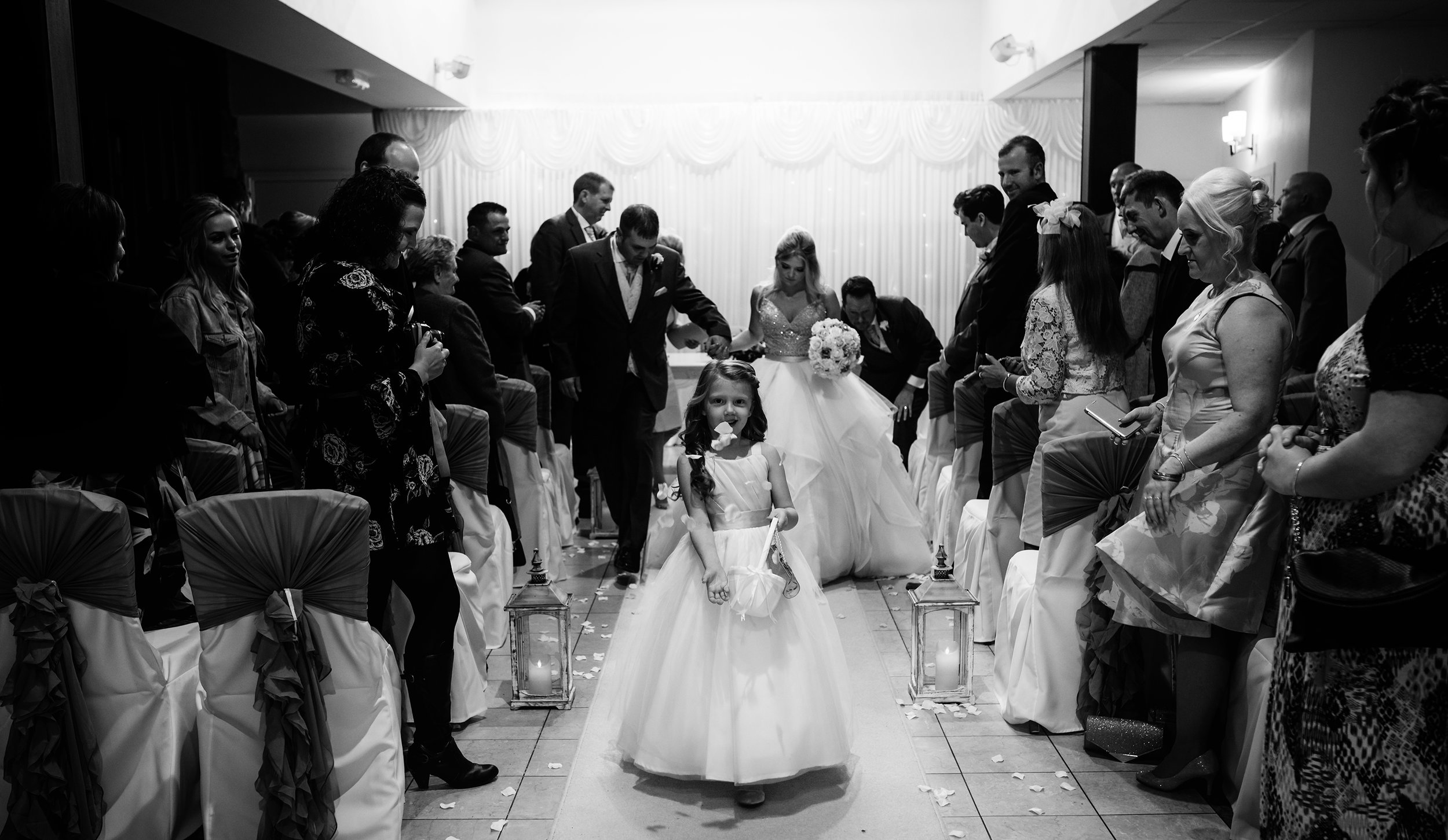 Flower girl sprinkling flowers during the happy couples exit
