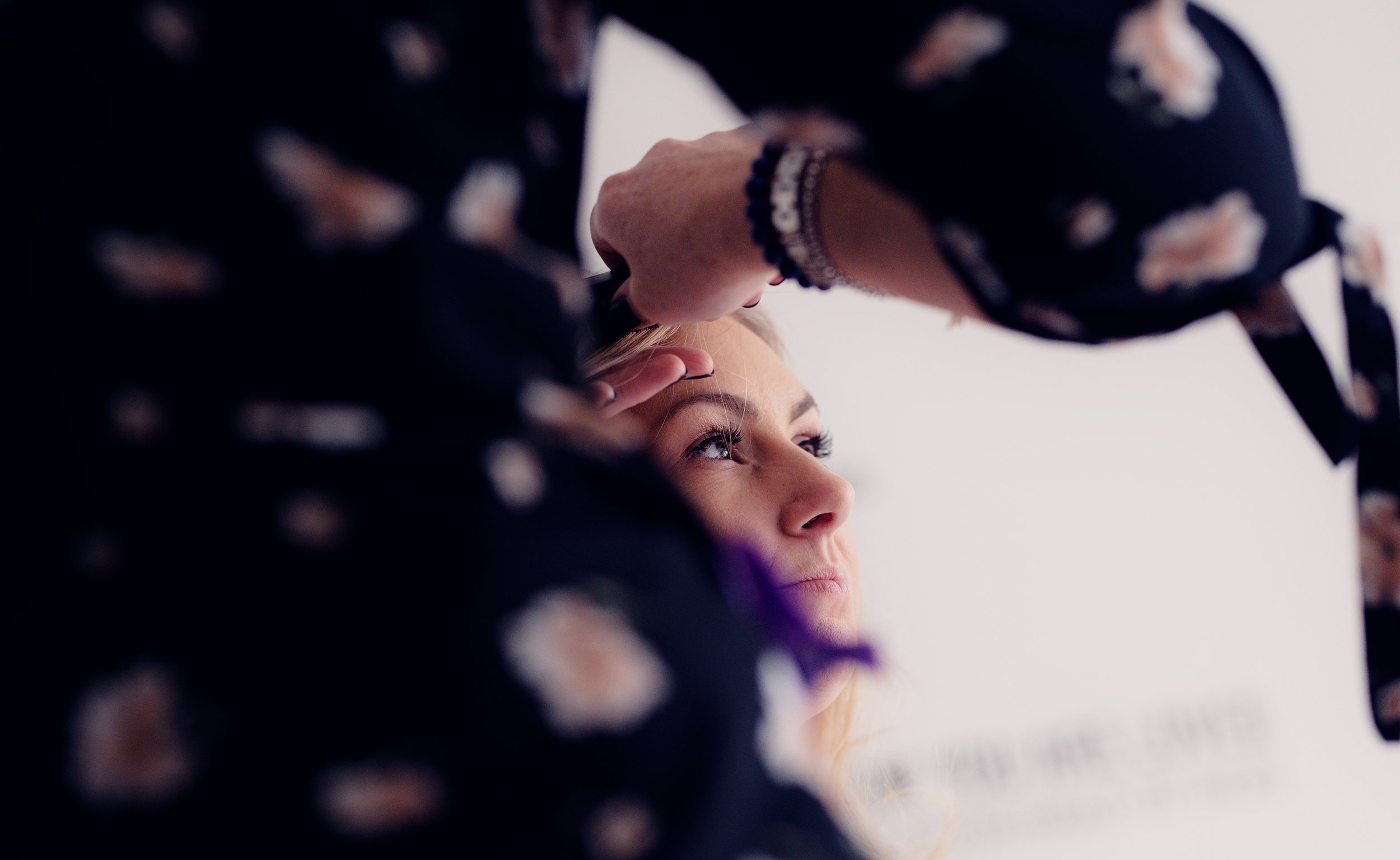 Sneaky shot of a bridesmaid having her hair done during bridal preparations