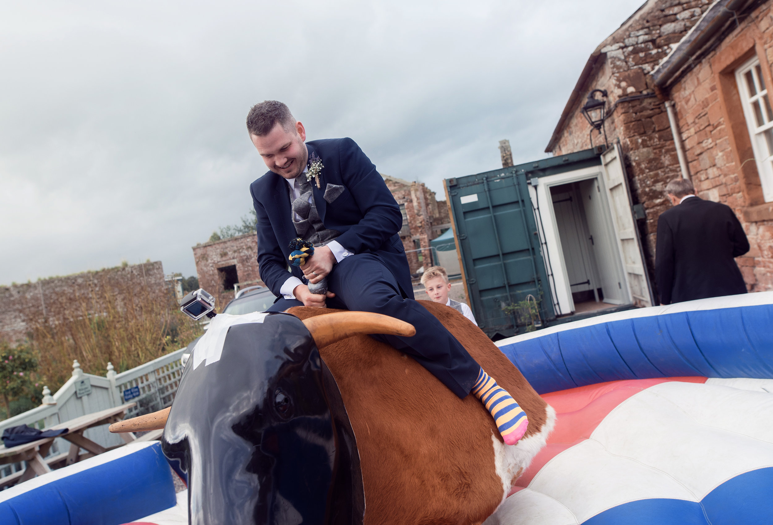 The groom doing his best to stay on the rodeo bull ride he did not last very long at all