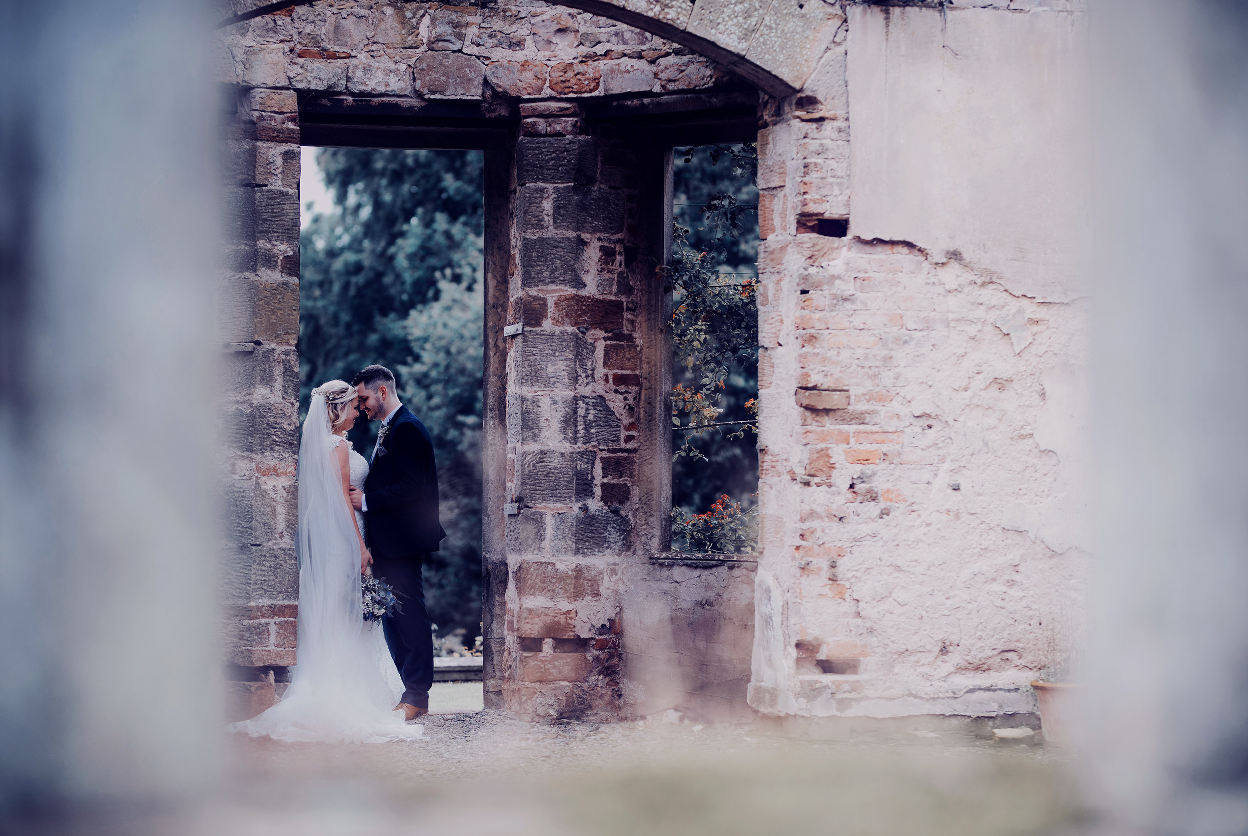 Bride and groom standing in a doorway Kirklinton Hall