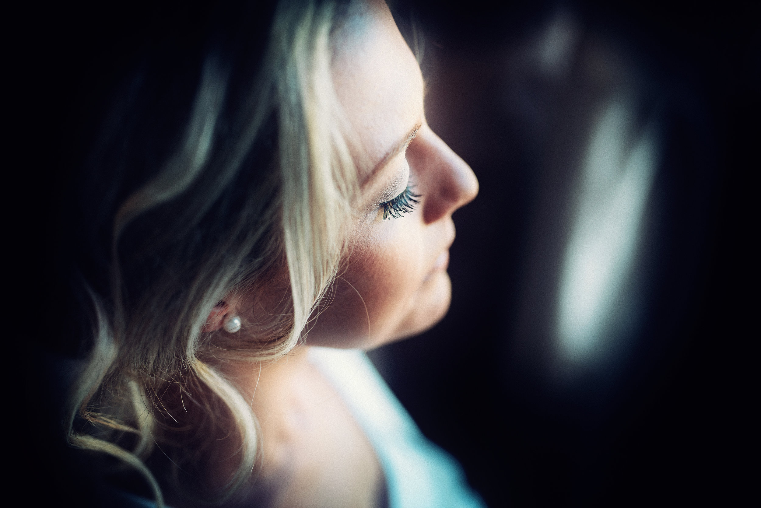 A bridesmaid in subdued light during bridal preparations