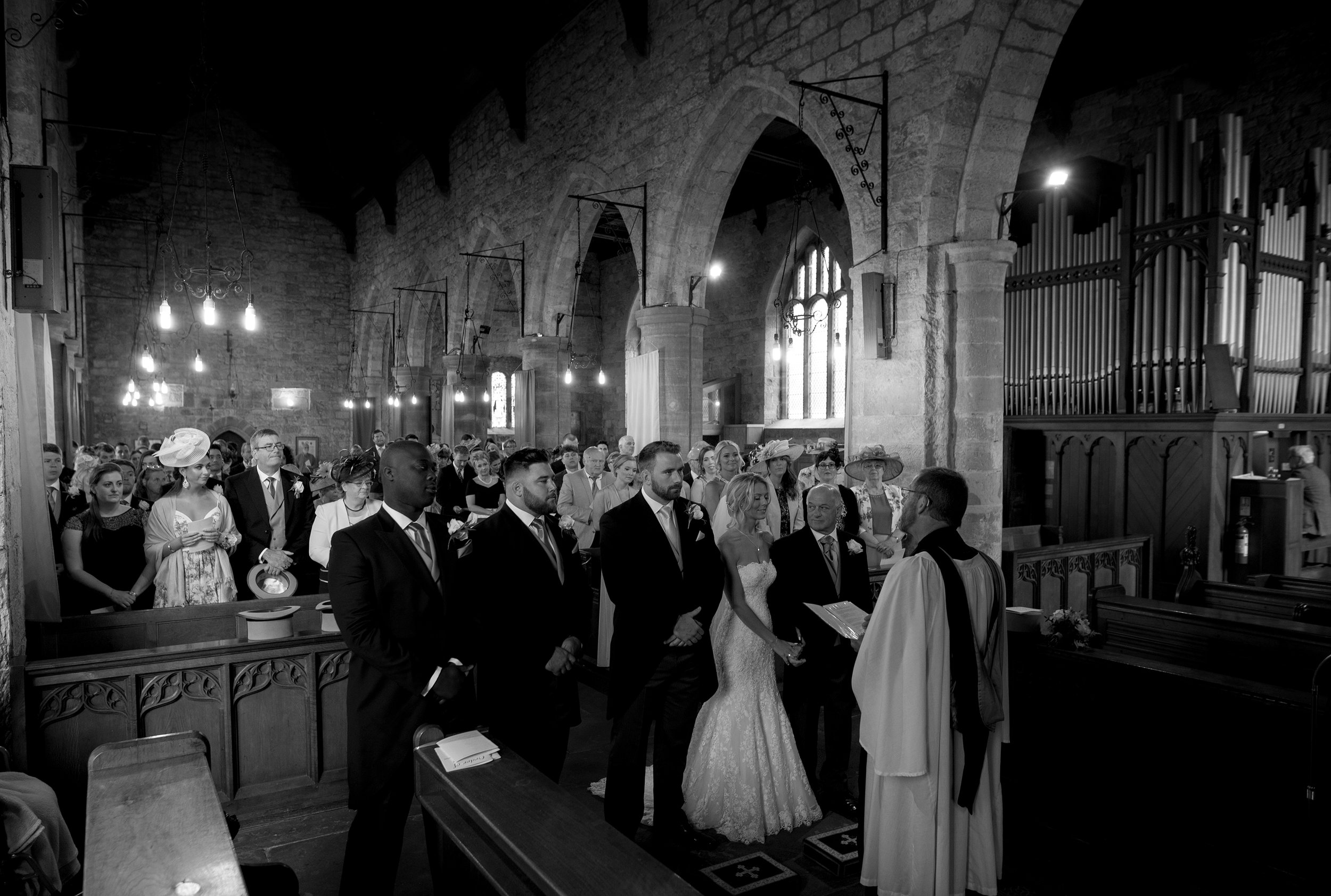 A black and white image of the bridal party in the church