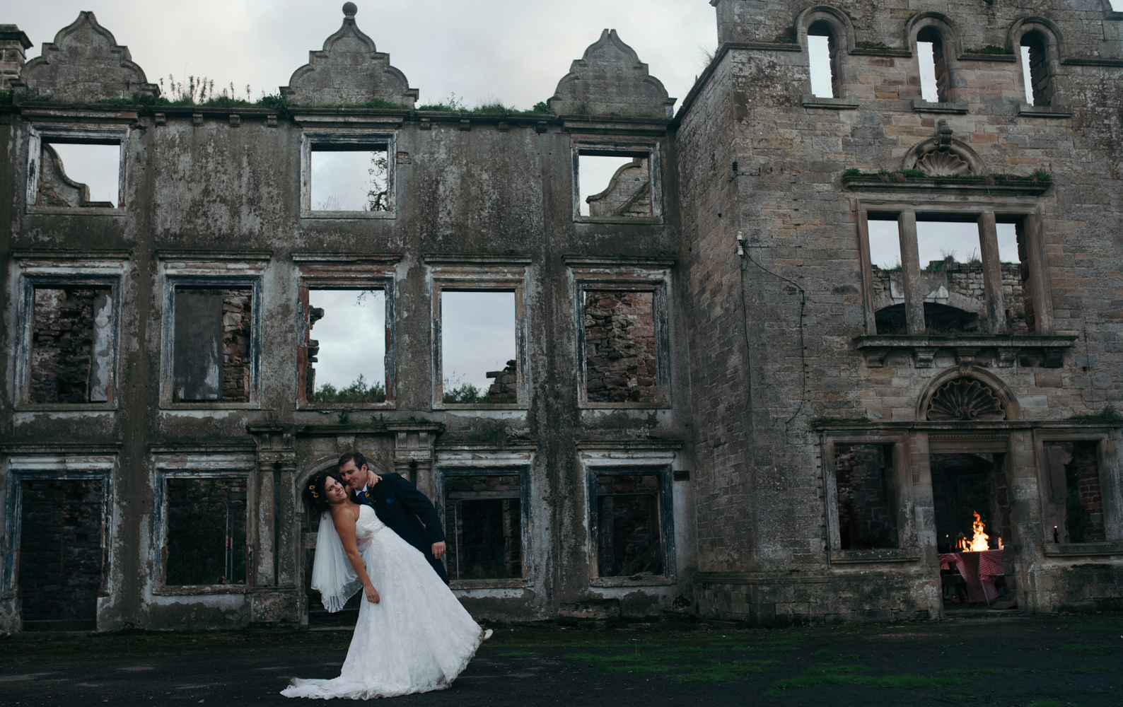 Bride and groom with the hall in the background