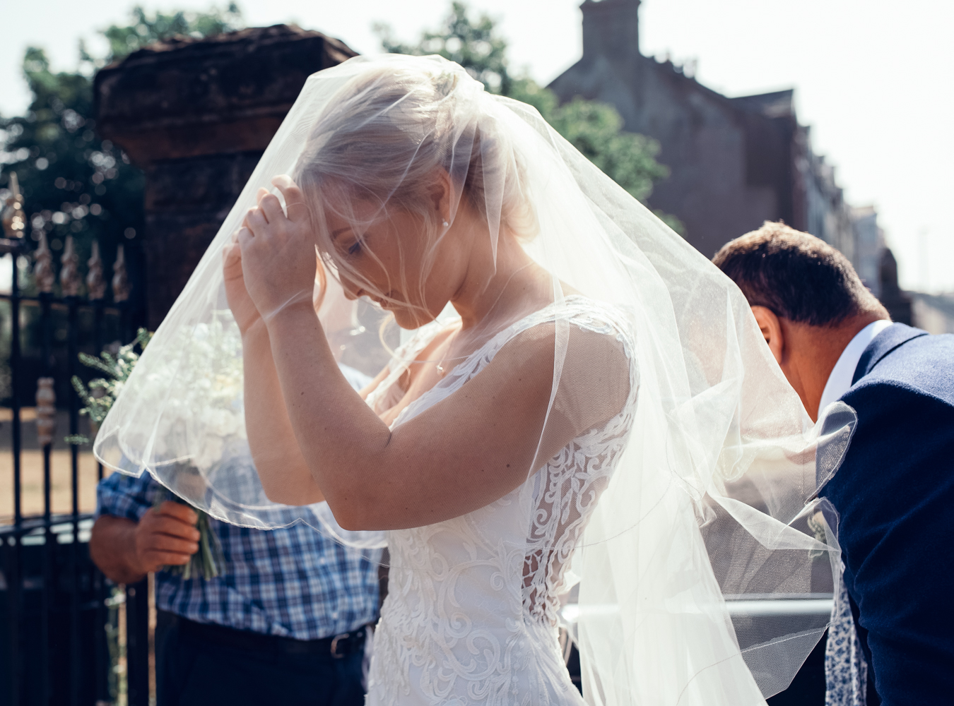 The bride adjusting her veil before going into church