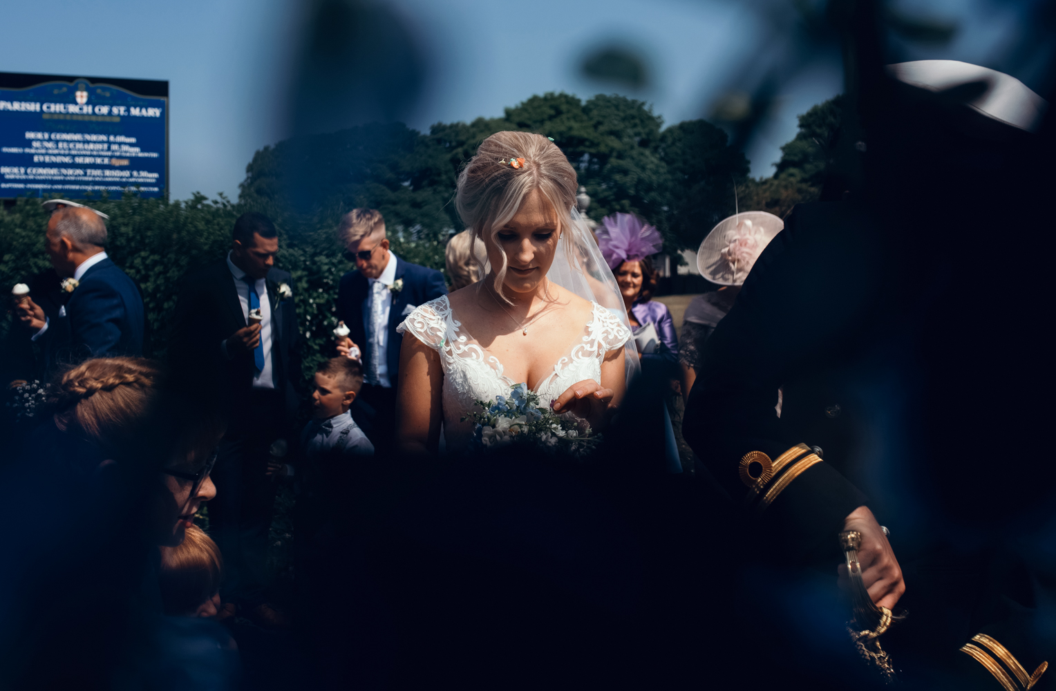 A photo of the bride through a wrought iron gate at the church after the ceremony