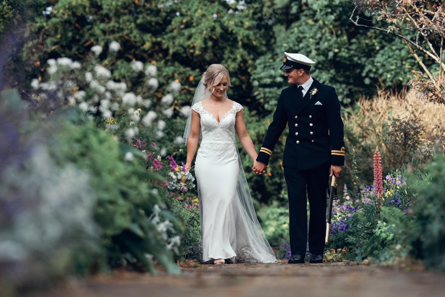The bride and groom taking a relaxing walk through the amazing gardens at Askham Hall
