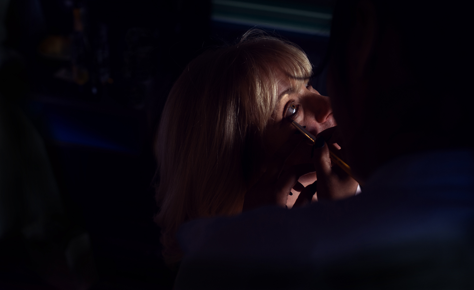 Dark and moody photo of the brides mum during morning preparations