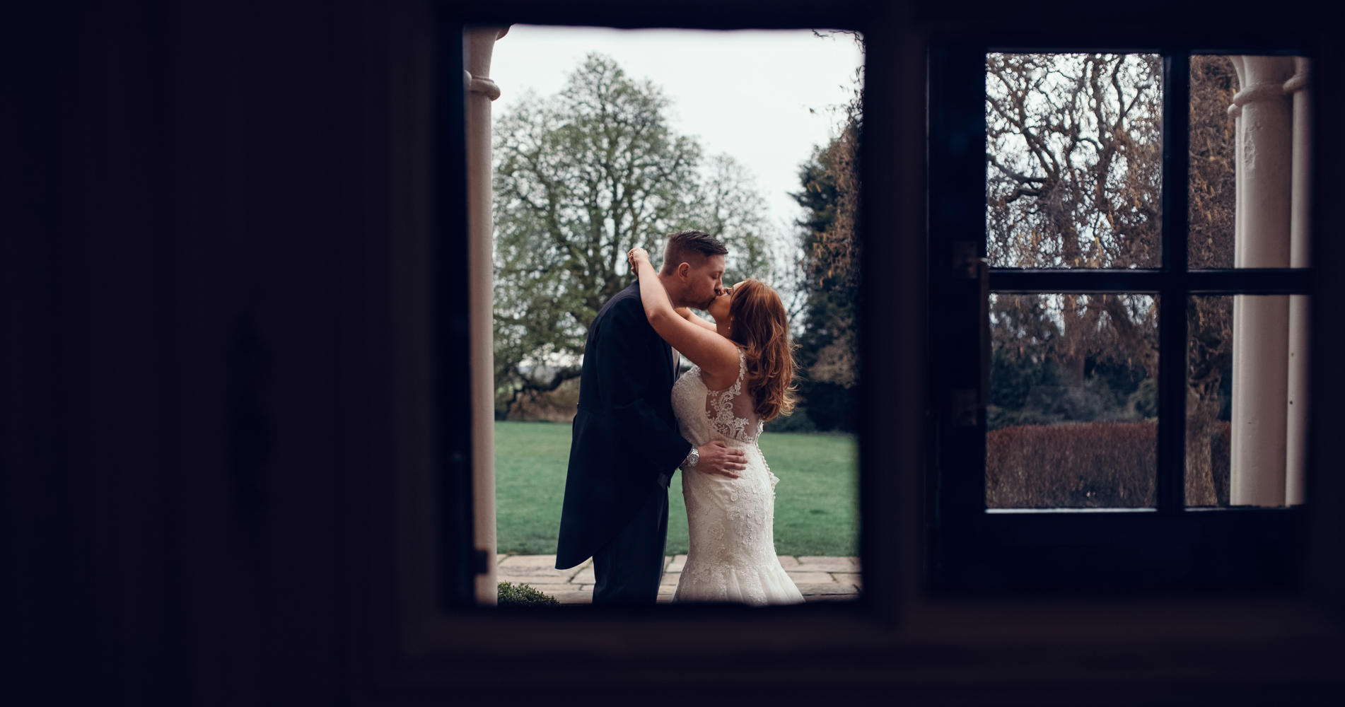 The bride and groom having a sneaky hug before going into the wedding breakfast