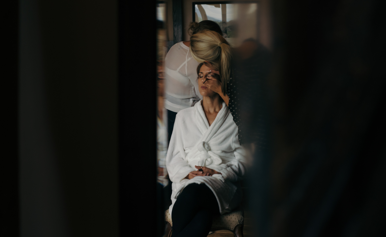 A bridesmaid having her makeup applied during morning bridal preparations