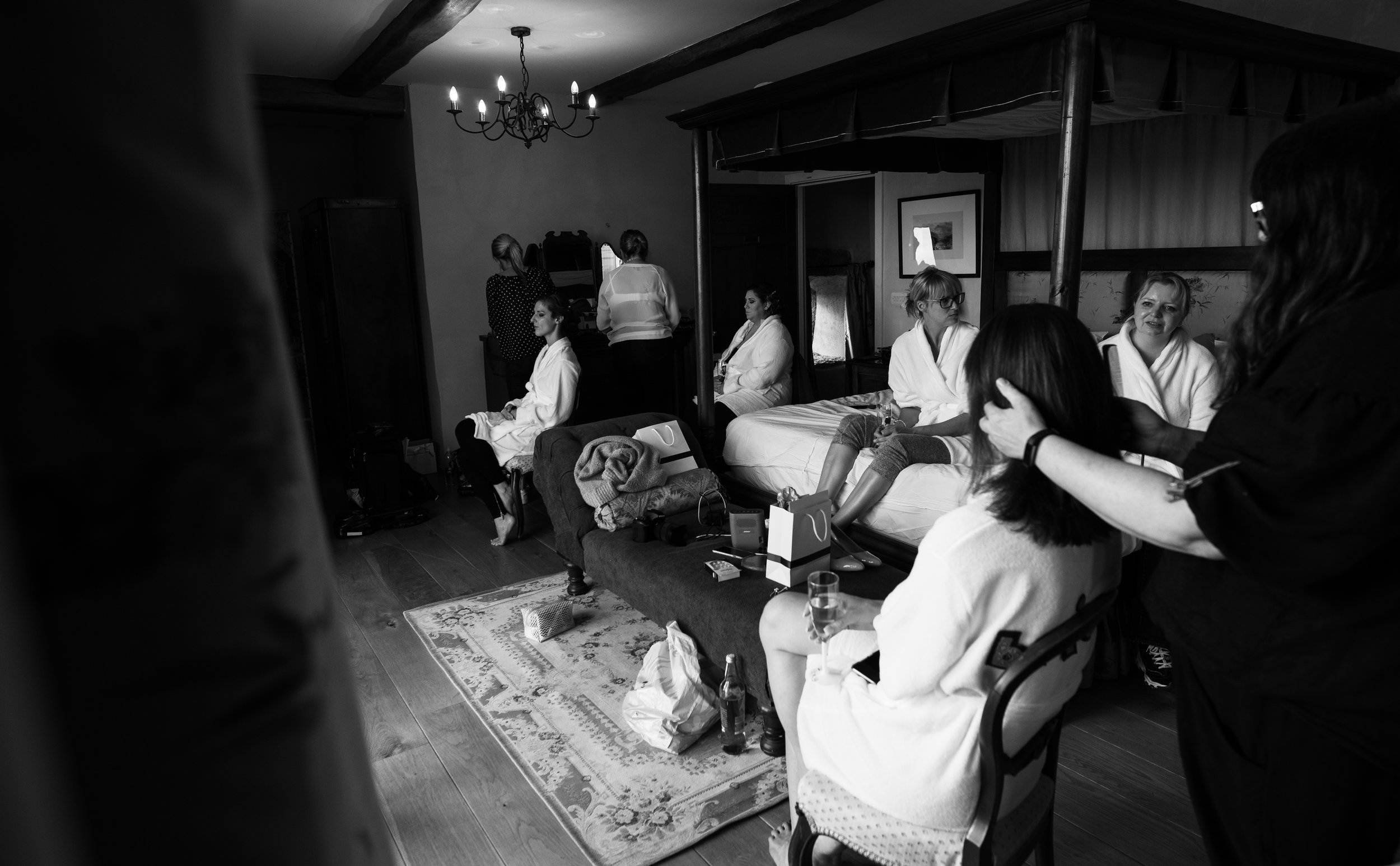 A wide angle black and white photo of the bride and bridesmaids getting ready