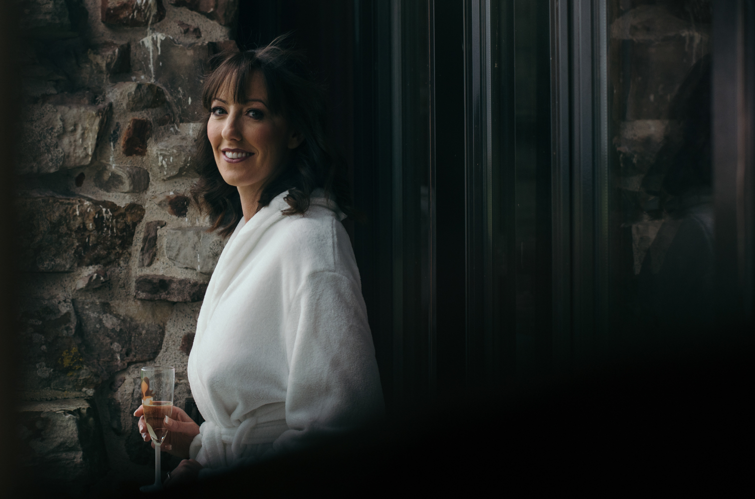 The bride Vicky standing out on the balcony overlooking the gardens at Blencowe Hall