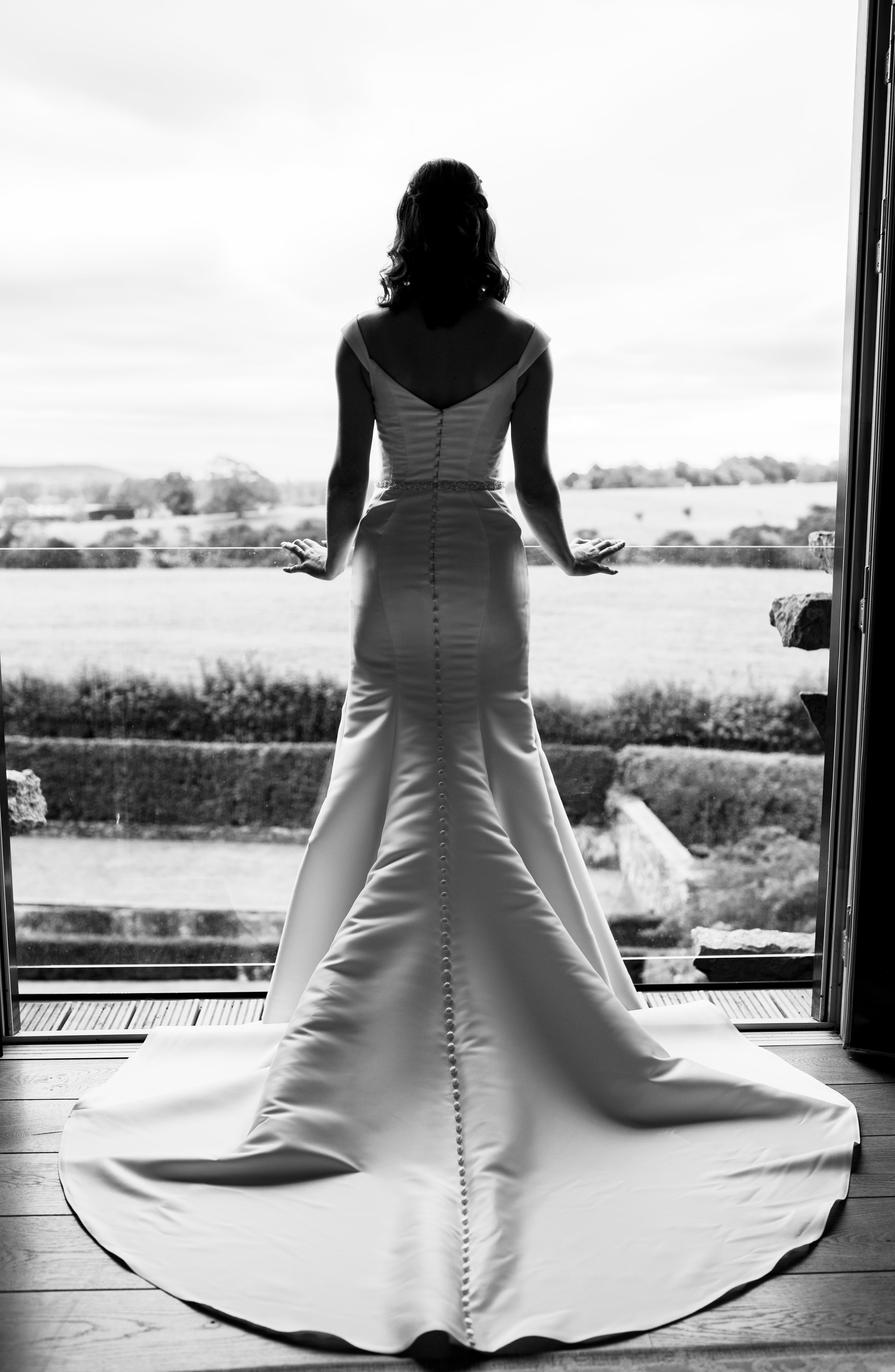 Black and white photo of the bride looking out across the Cumbrian countryside 
