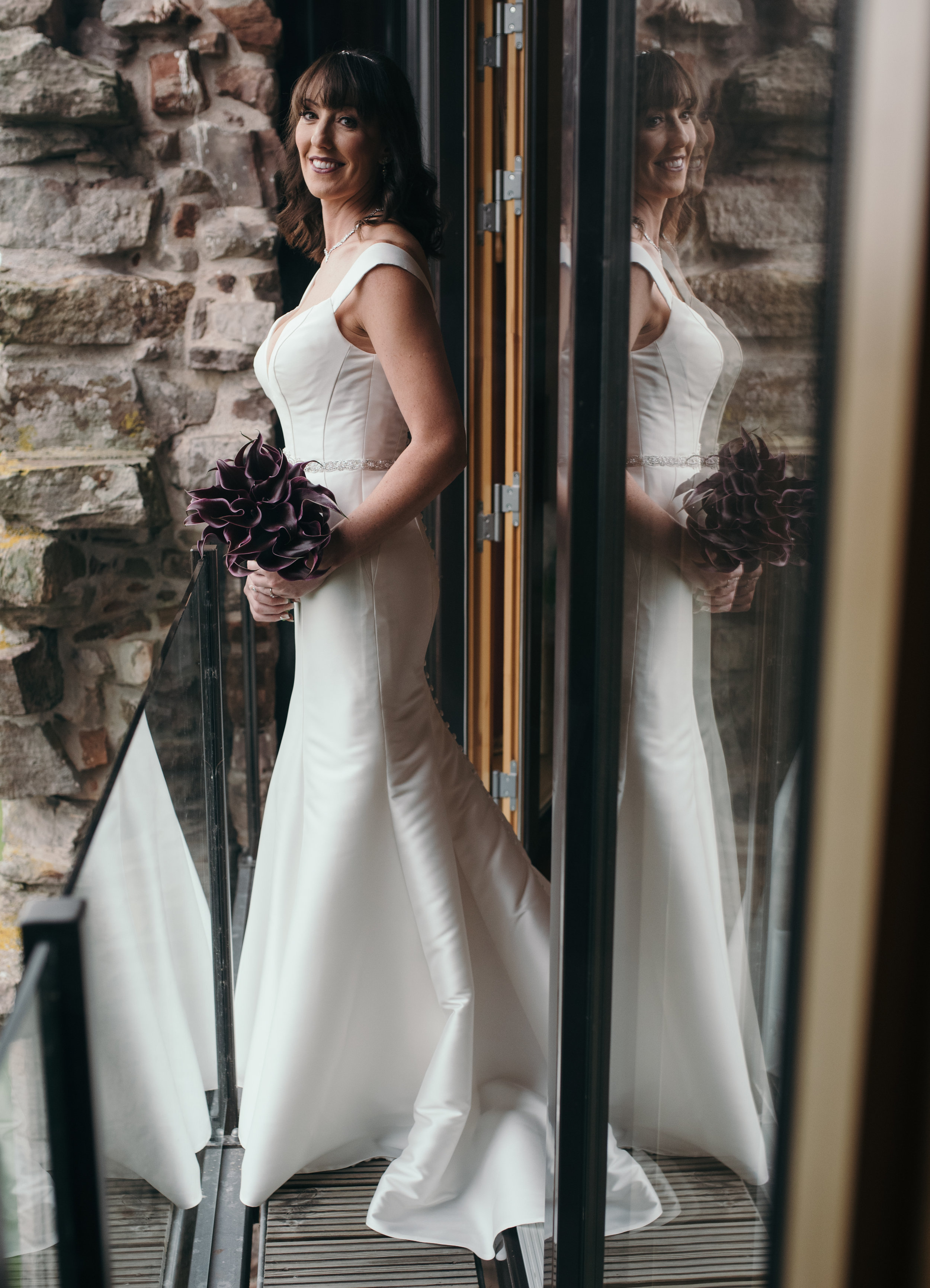 The bride standing on the balcony looking back into the bedroom