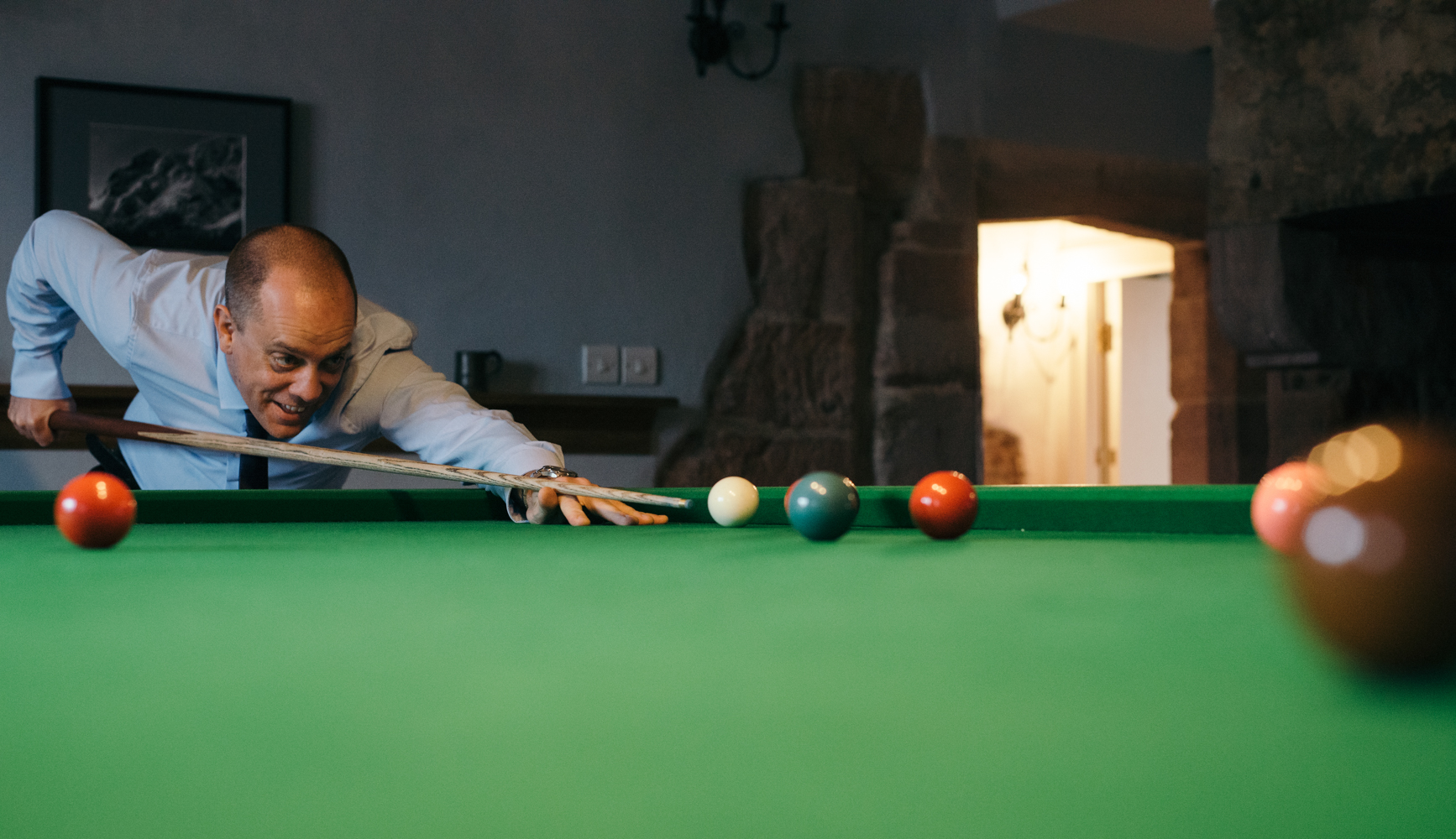 One of the male guests enjoying a game of snooker before the wedding ceremony