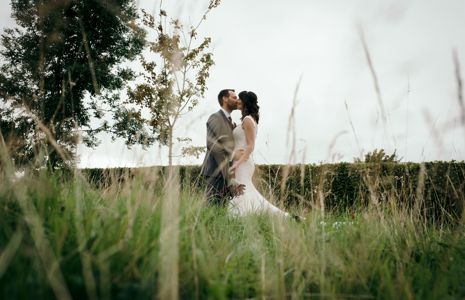 The bride and groom standing in the garden during a portrait session