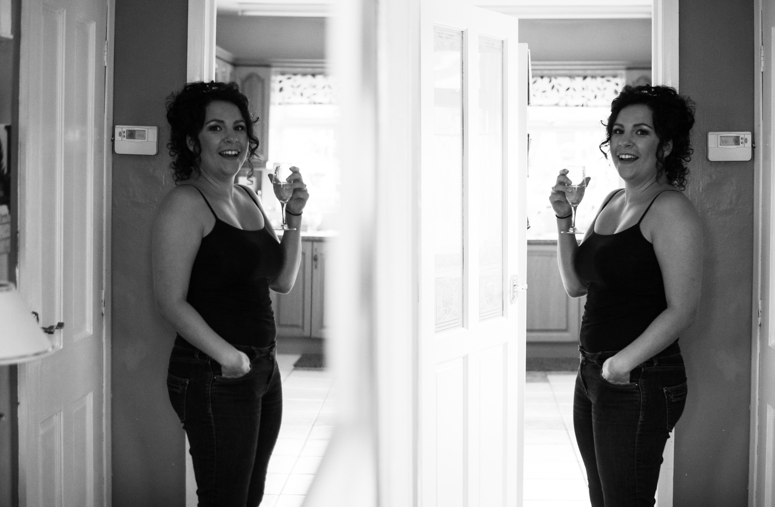 The bride standing in her parent hallway with a mirror on the opposite wall for reflection