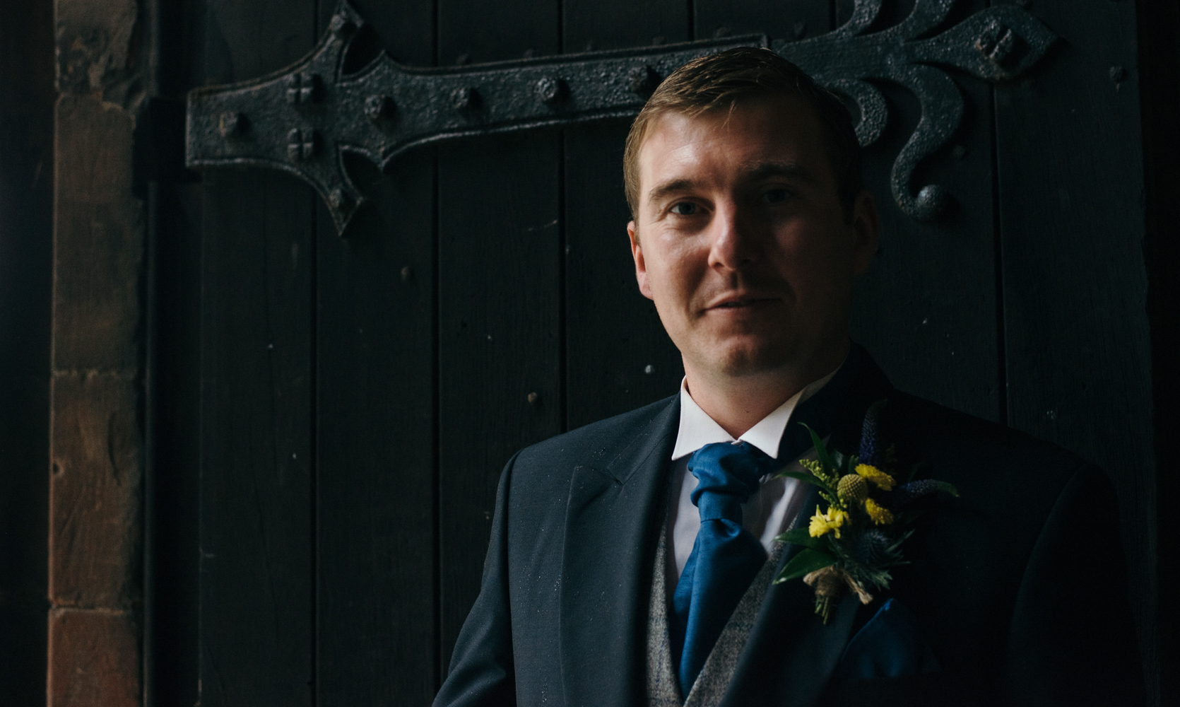 The groom portrait standing in the doorway waiting to welcome wedding guests