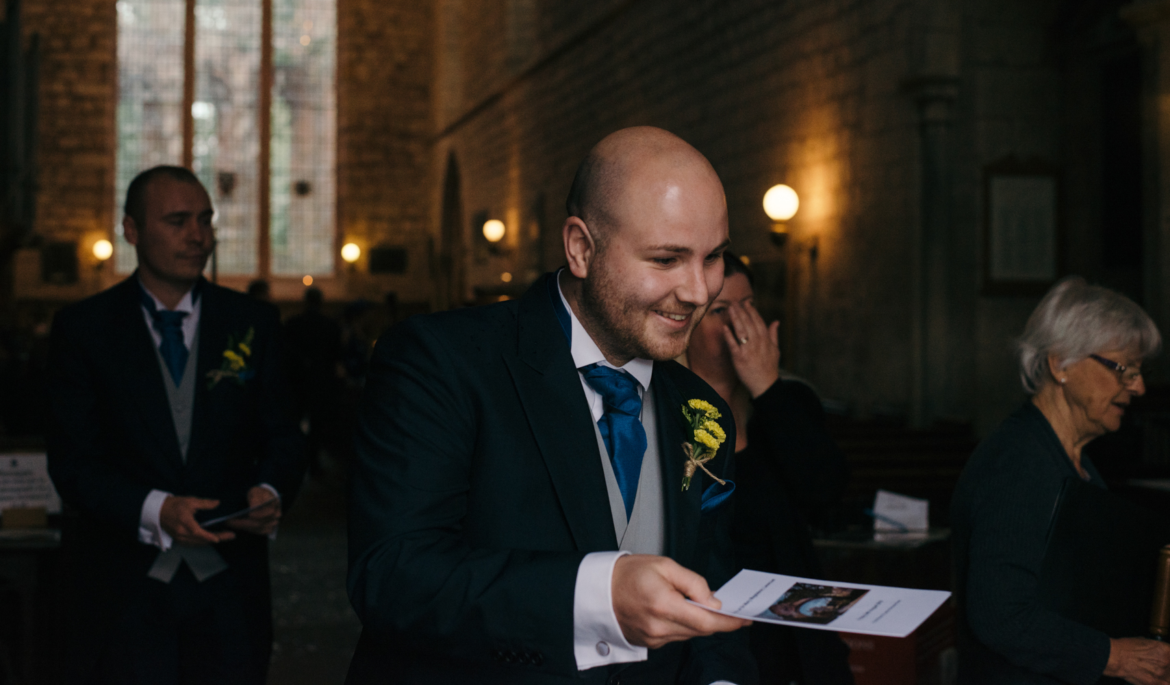 The best man handing out order of service sheets