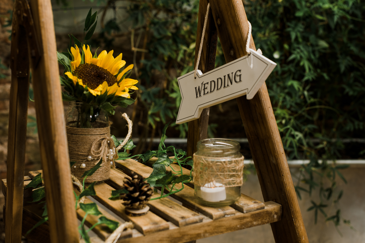 A decorated stepladder with lots of flowers and candles