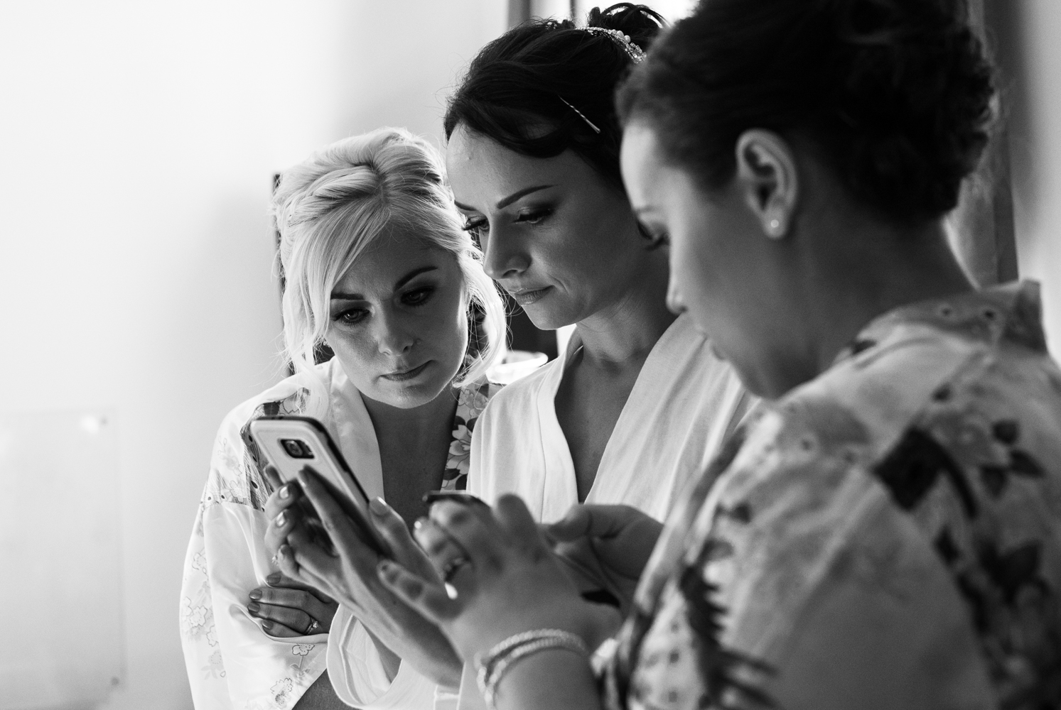 The bride and bridesmaid looking at a message on a mobile phone