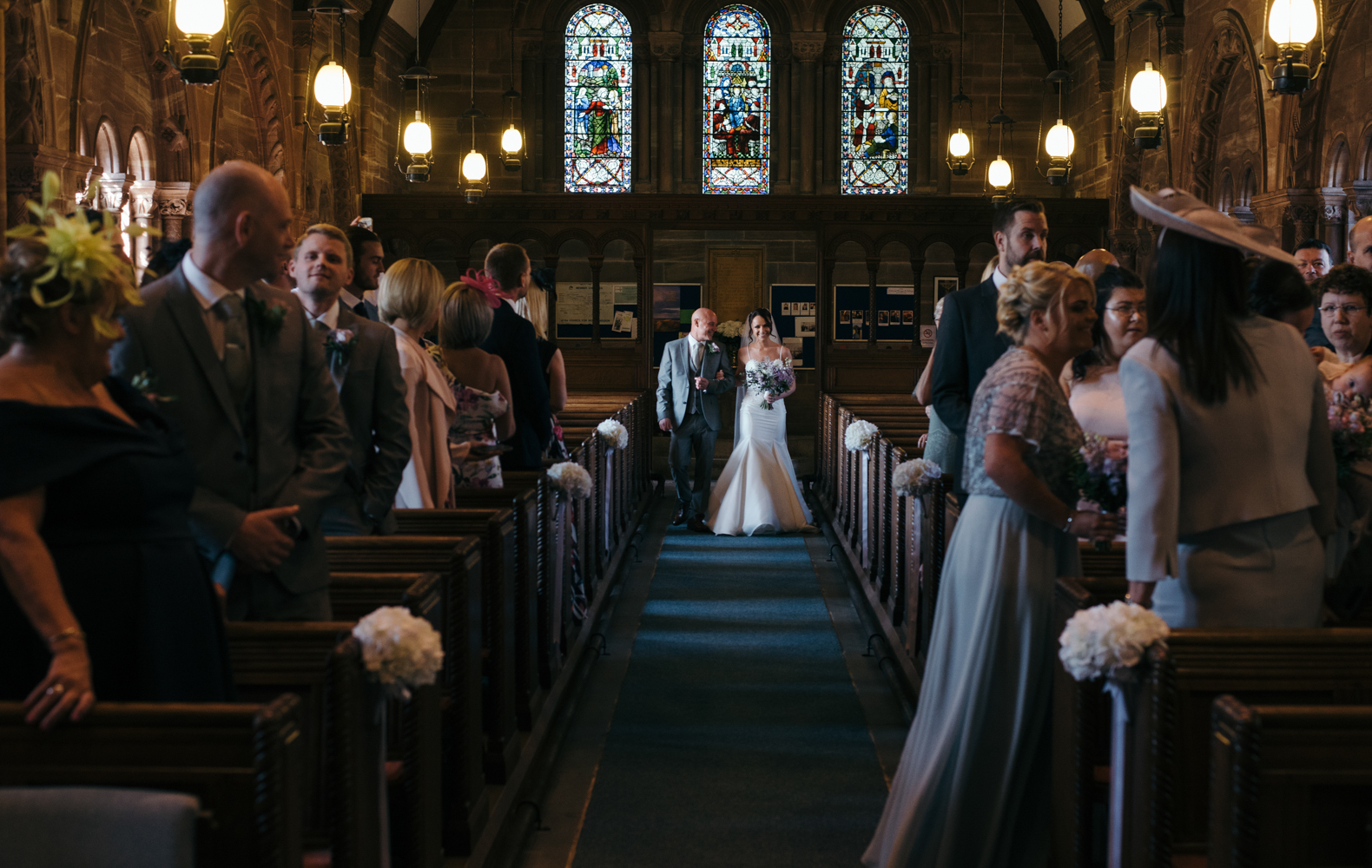 The bride and her father walking down the aisle in church 