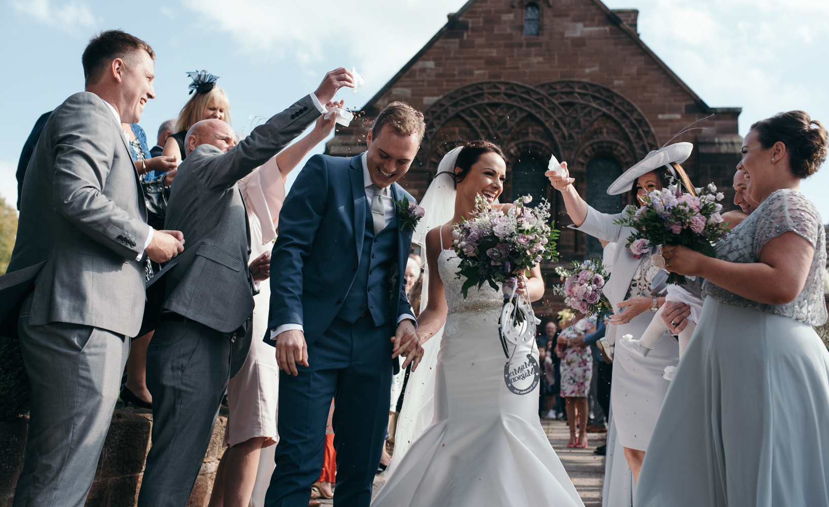 The bride and groom being covered in confetti