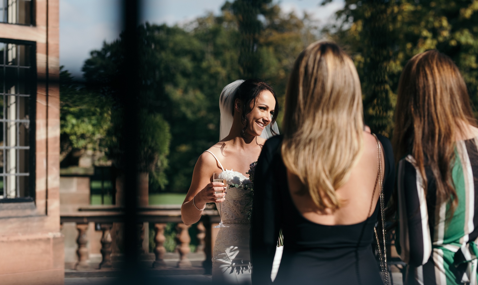 The bride chatting with two of her friends during the drinks reception at Inglewood Manor