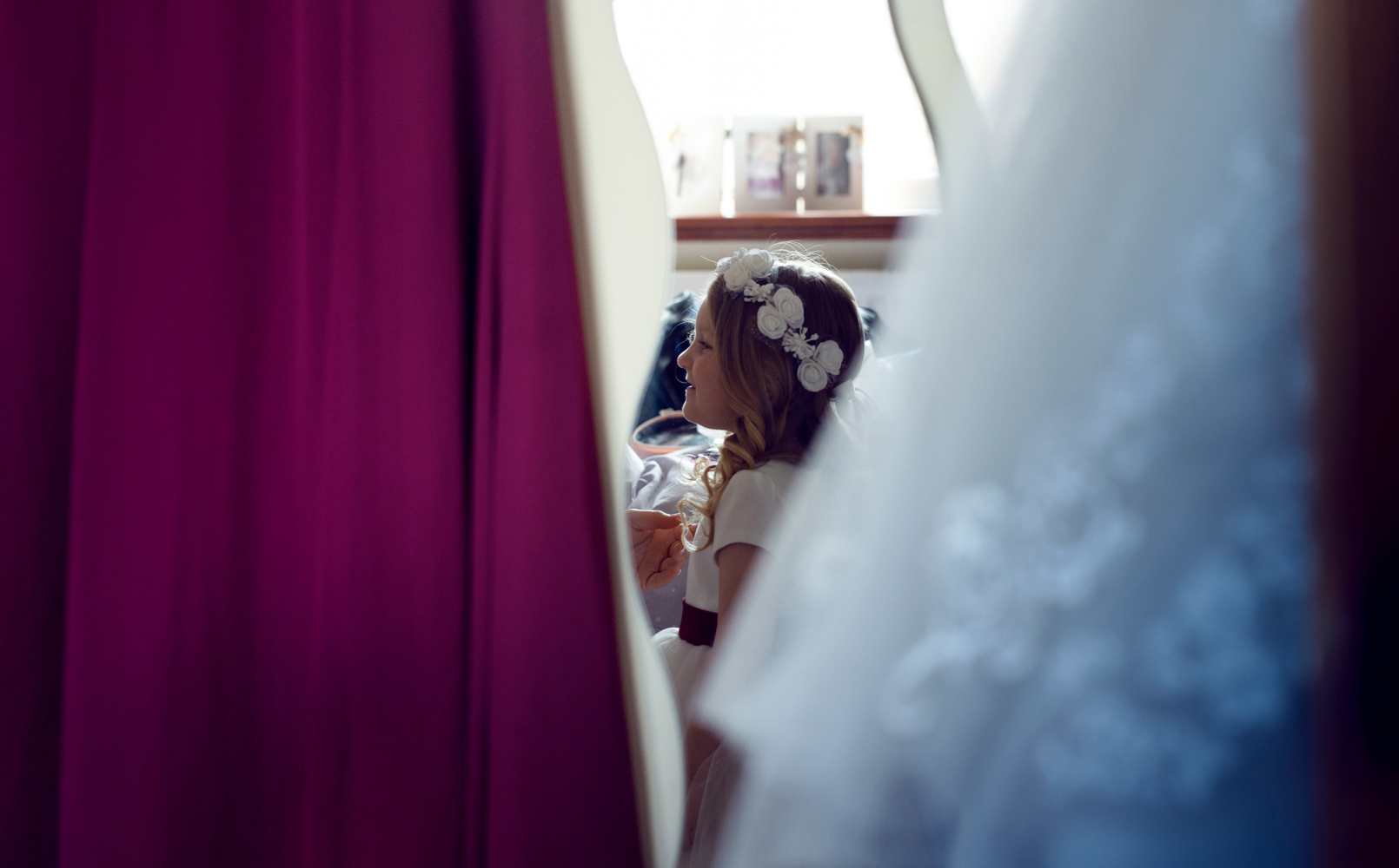 A little bridesmaid looking at the bride in her wedding dress