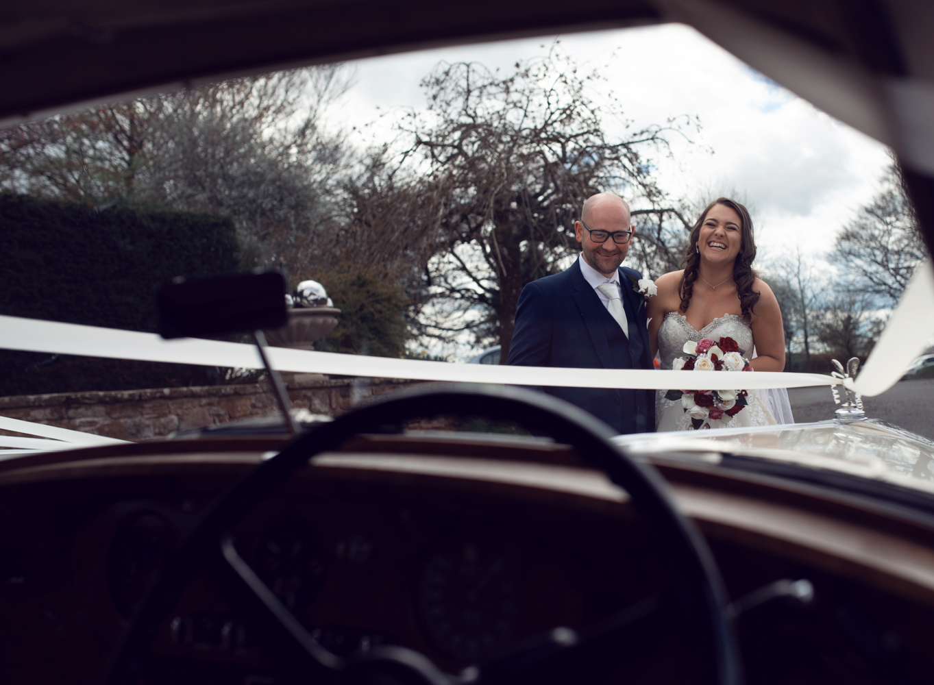 Photo of the bride and groom from inside the car