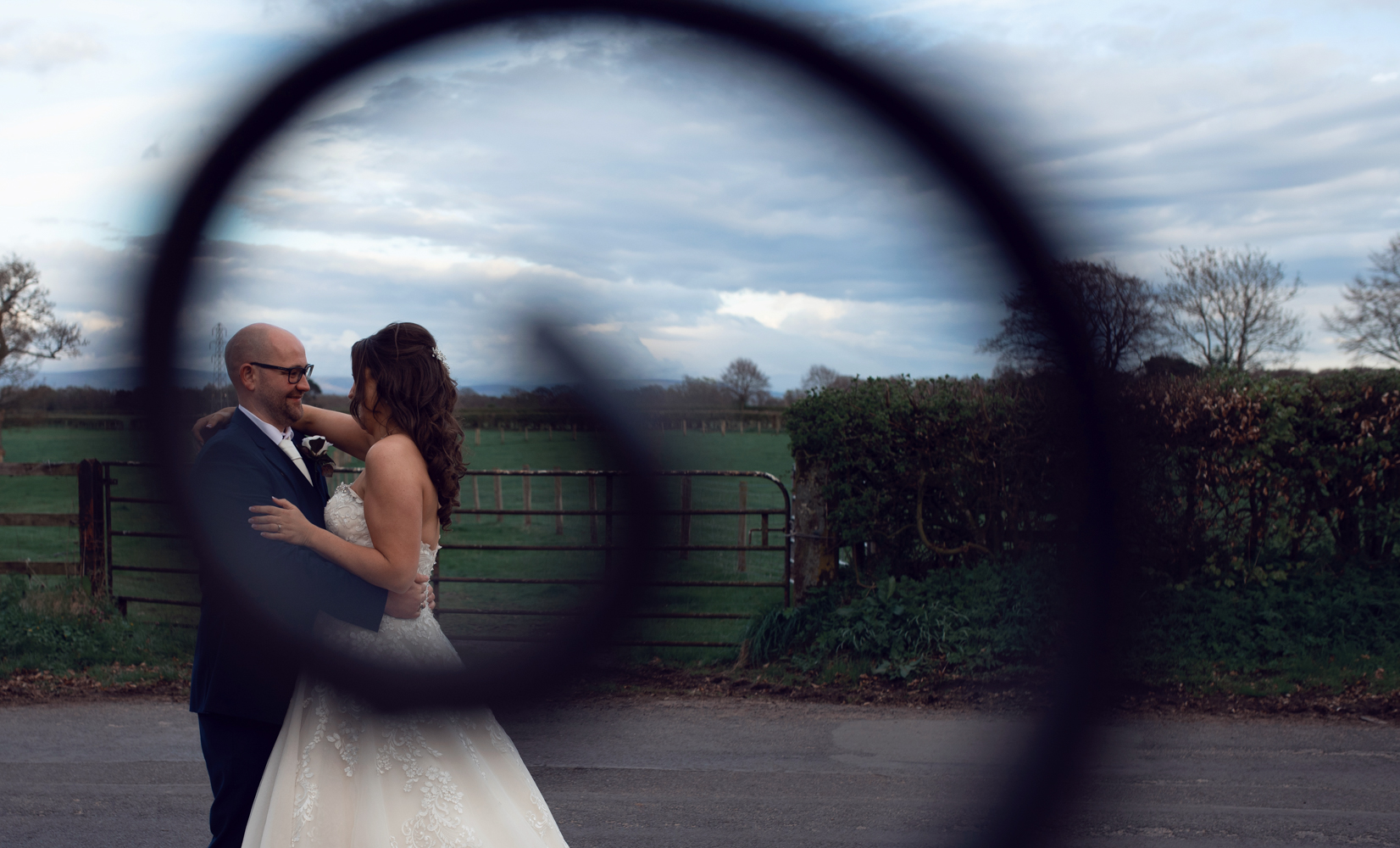 Photo of the bride and groom taken through a wrought iron gate swirl