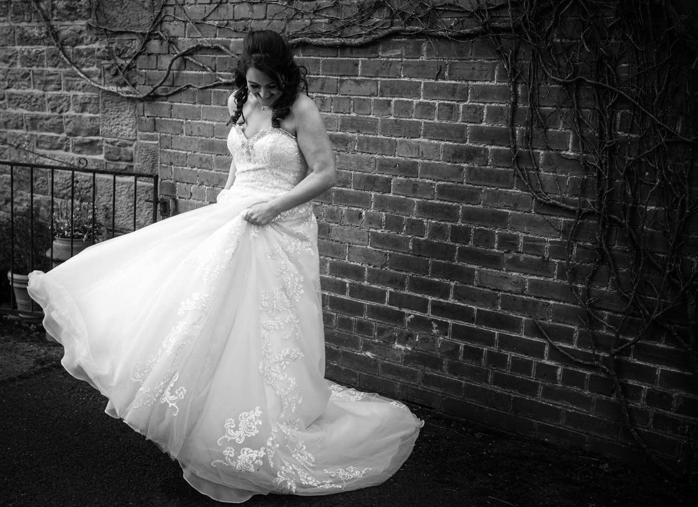 Black and white photo of the bride swirling her wedding dress around