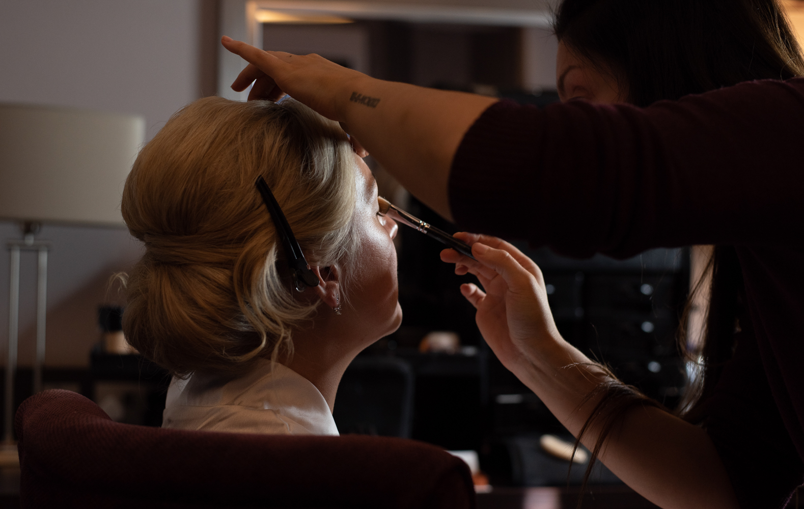 The bride having her makeup applied during morning preparations