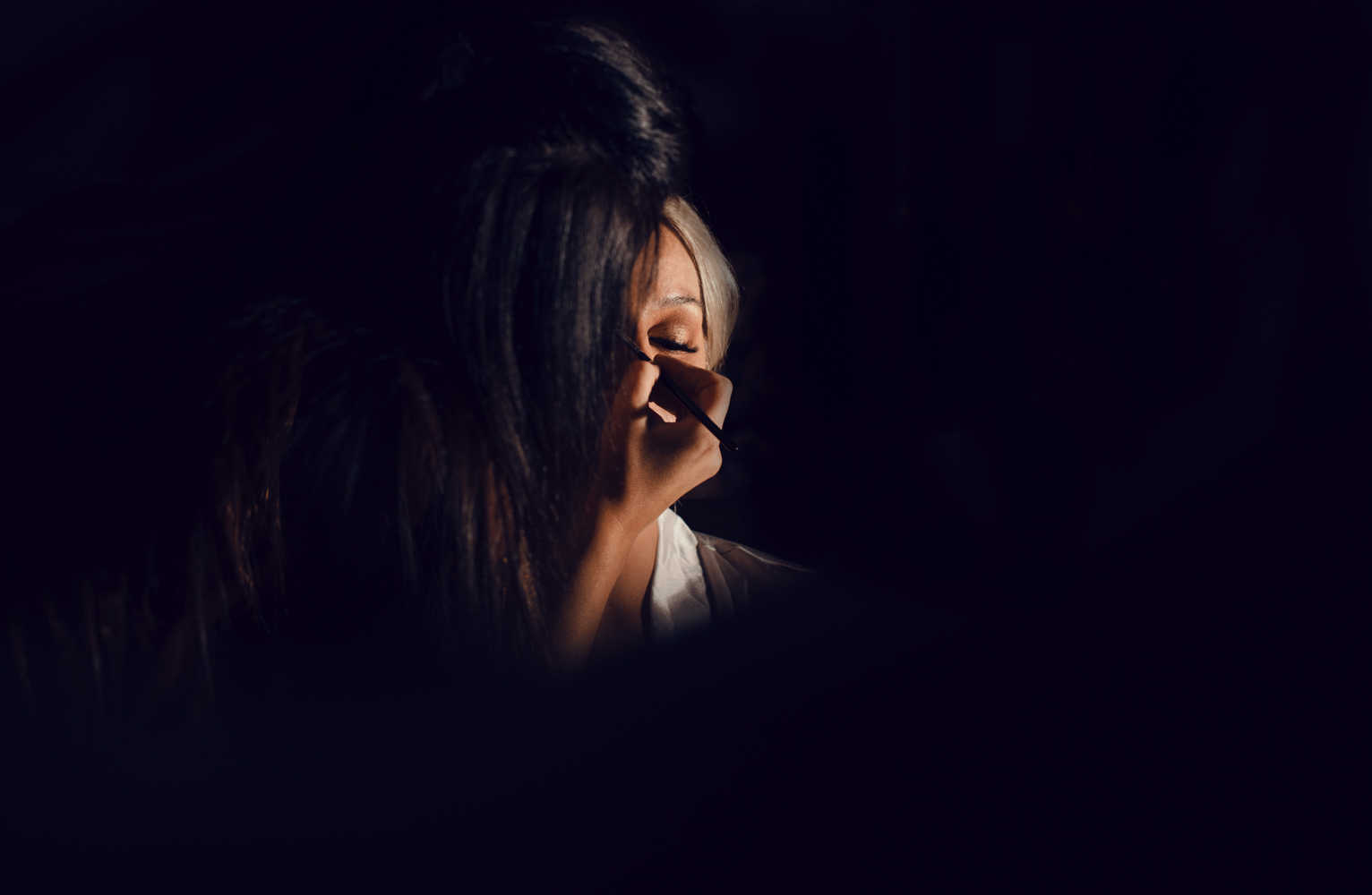 The bride having a final eye makeup touch up before going downstairs to the wedding ceremony