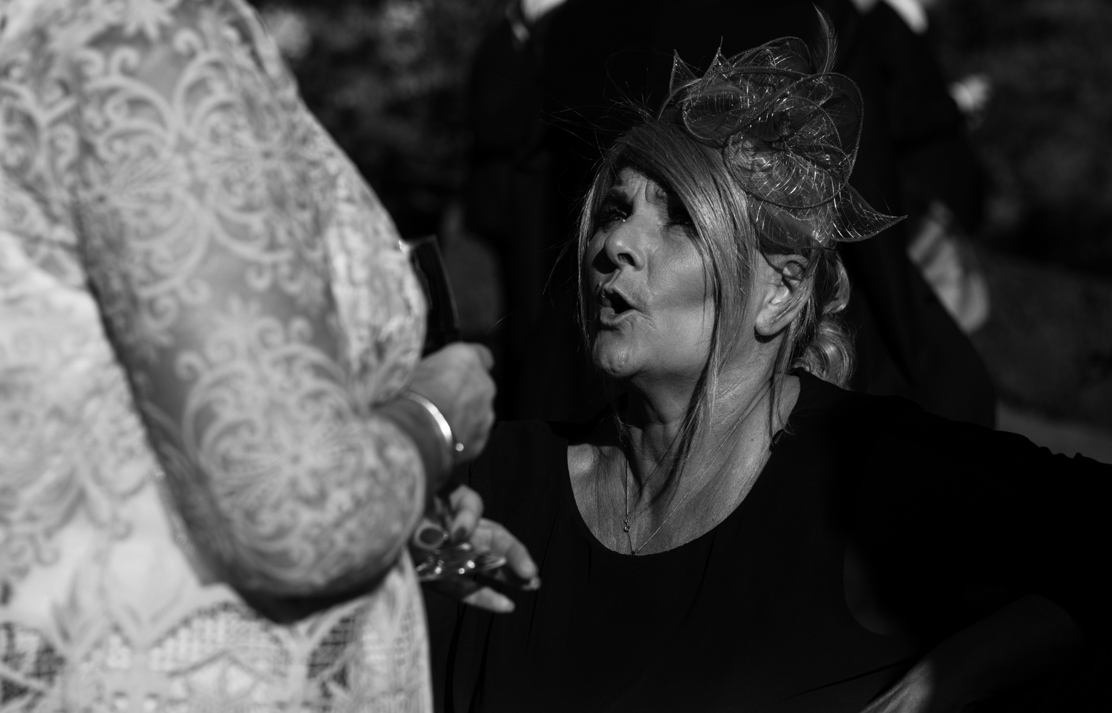 A black and white photo of one of the wedding guests during the drinks reception