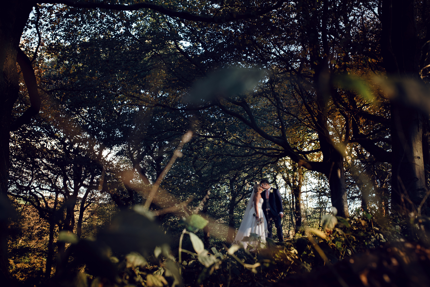 The bride and groom in the woods during the couples portrait session