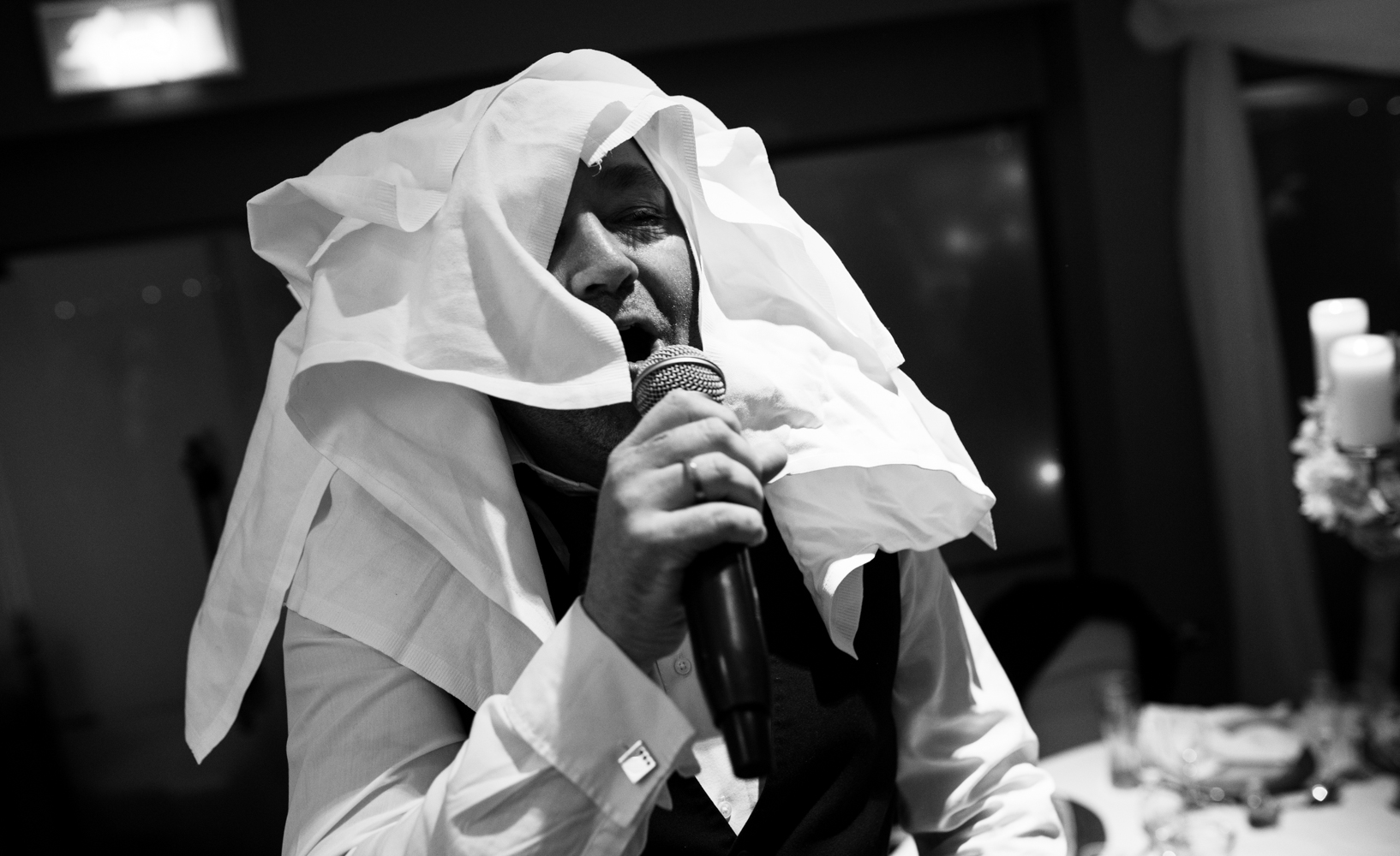 Black and white images of one of singing waiters with his head covered in table napkins