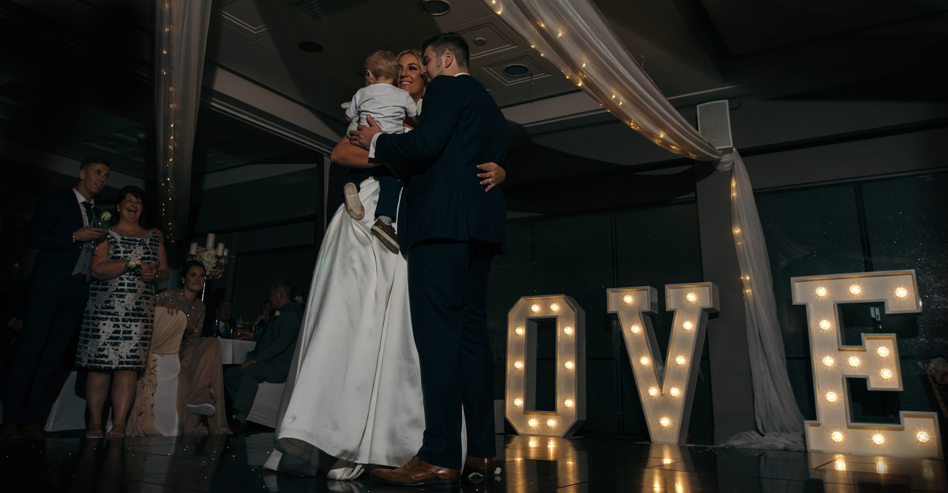 The bride and groom during the first dance with their little boy
