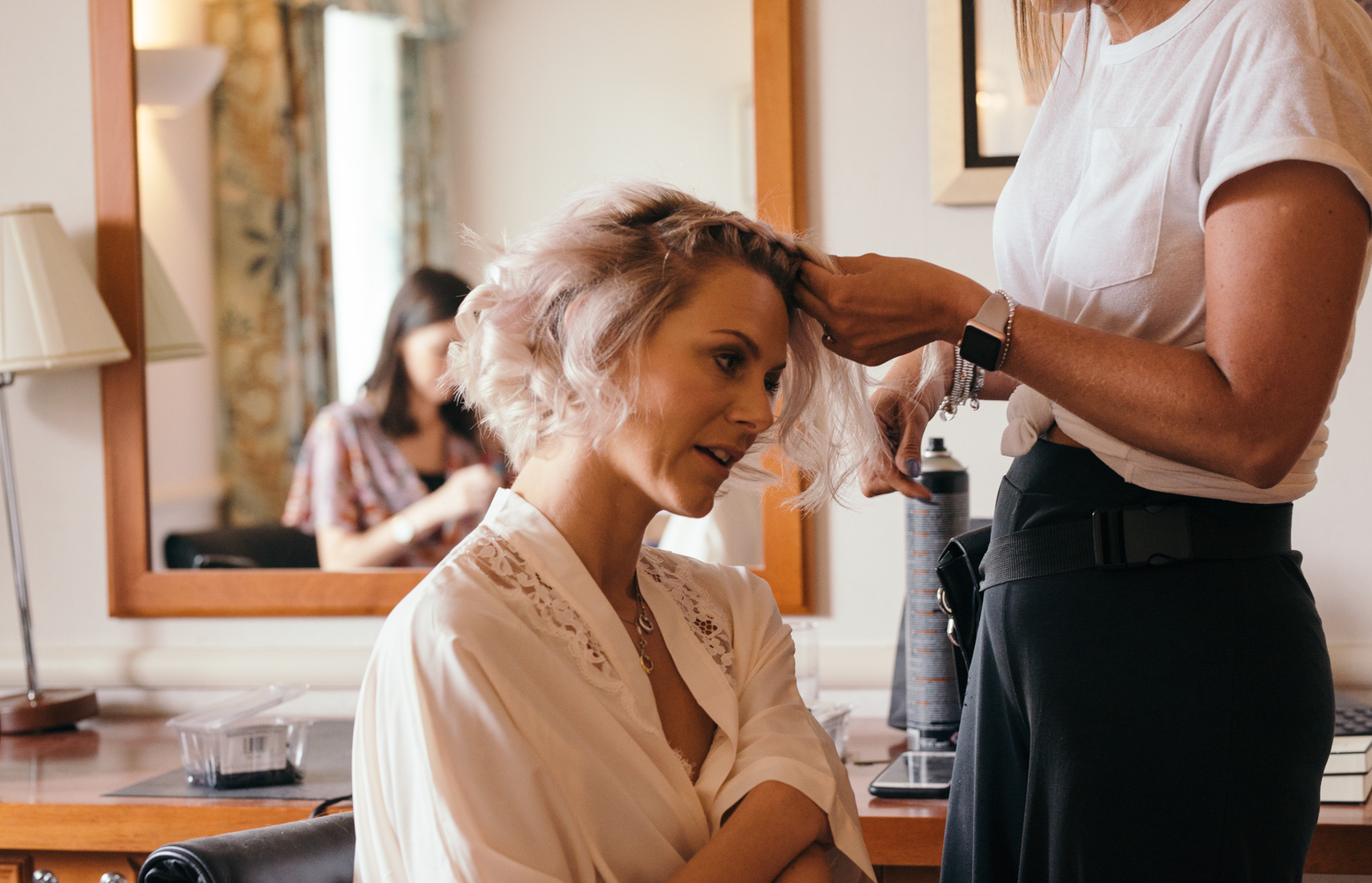 A bridesmaid having her hair done during morning preparations