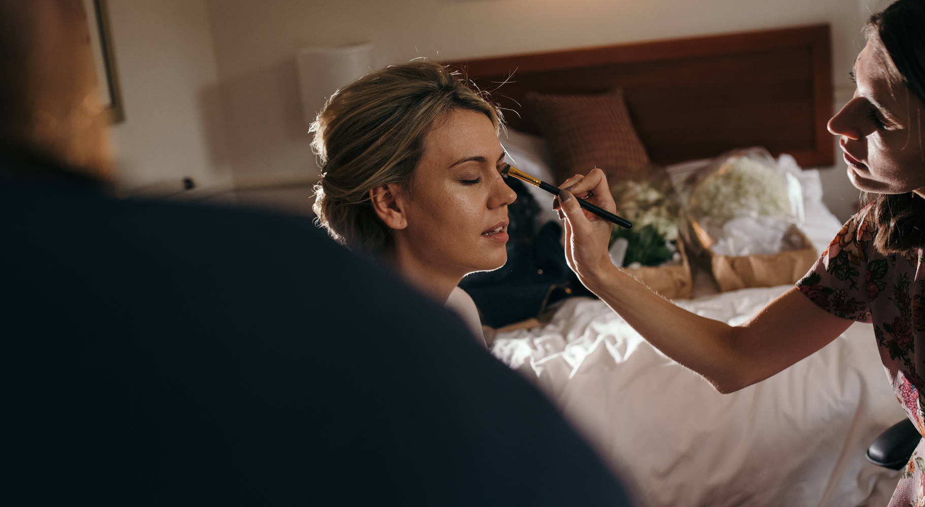 The bride having makeup and hair done during morning preparations