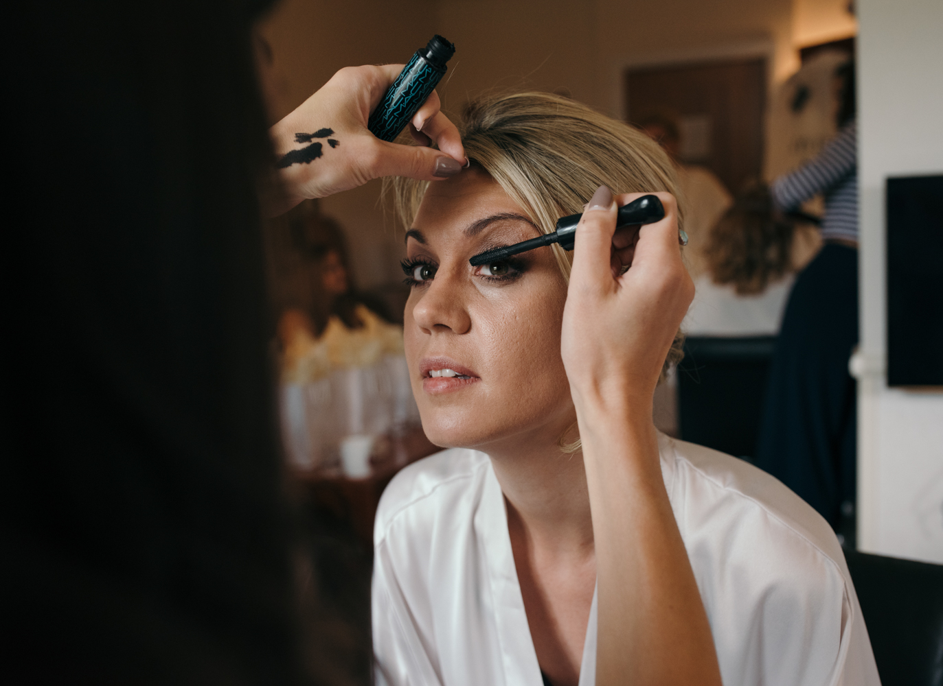 The bride having her eye makeup applied.