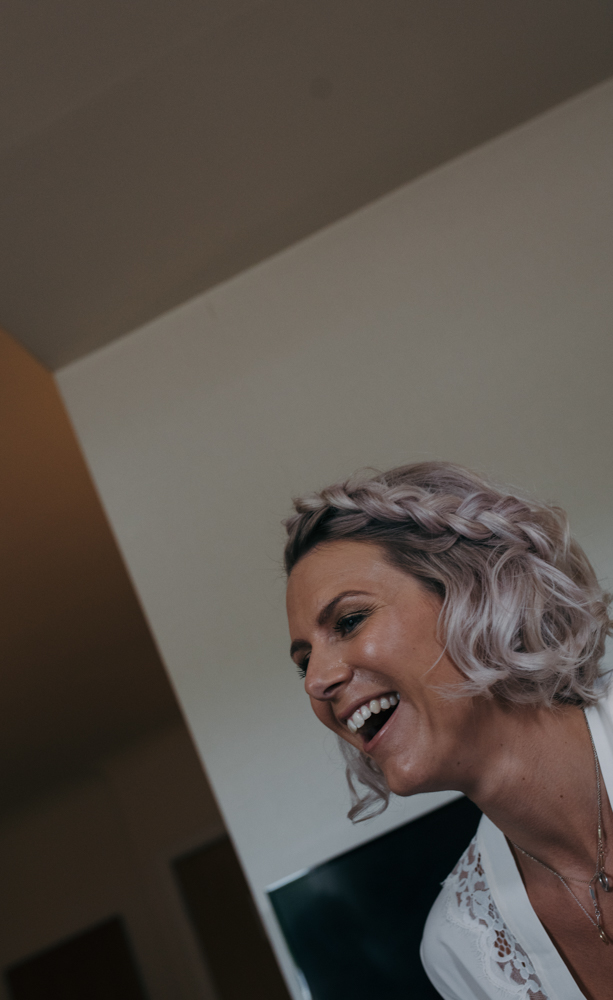 A wacky angle photo of a bridesmaid laughing