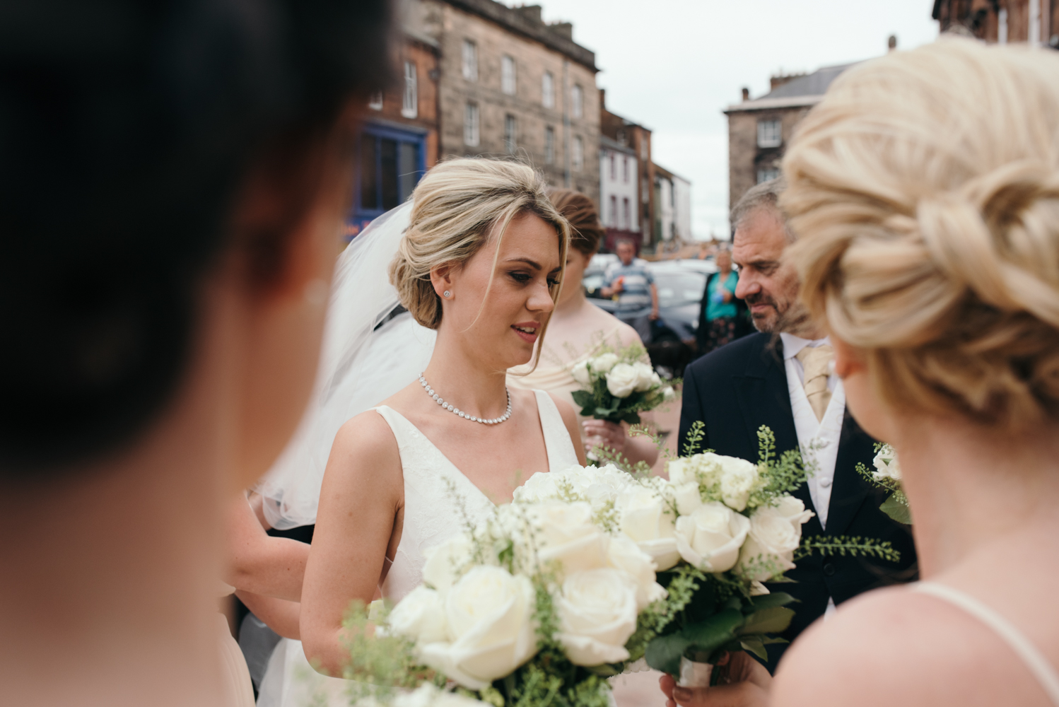 The bridesmaids make final adjustments to the brides dress before going into church