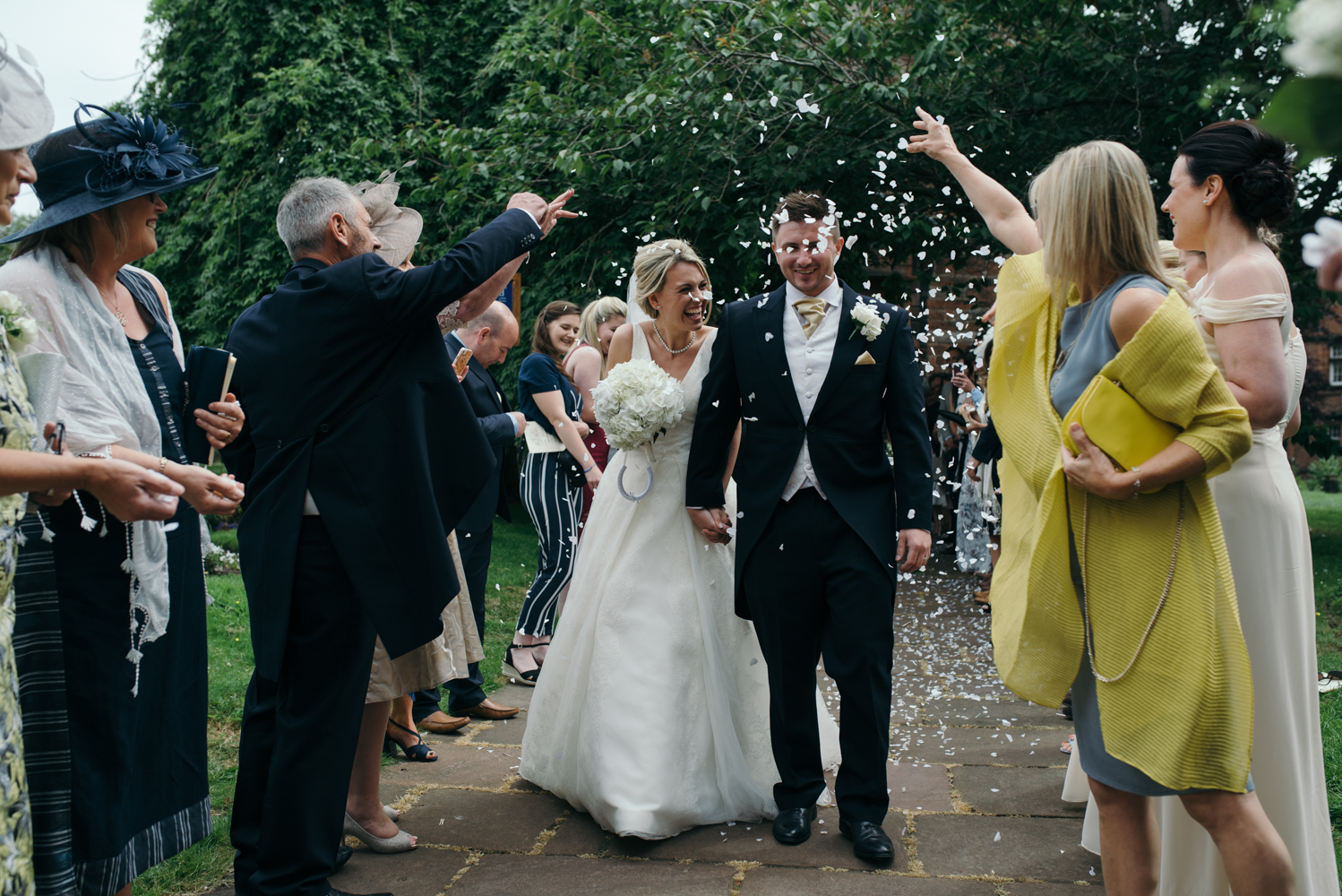 The bride and groom walking through the confetti shower