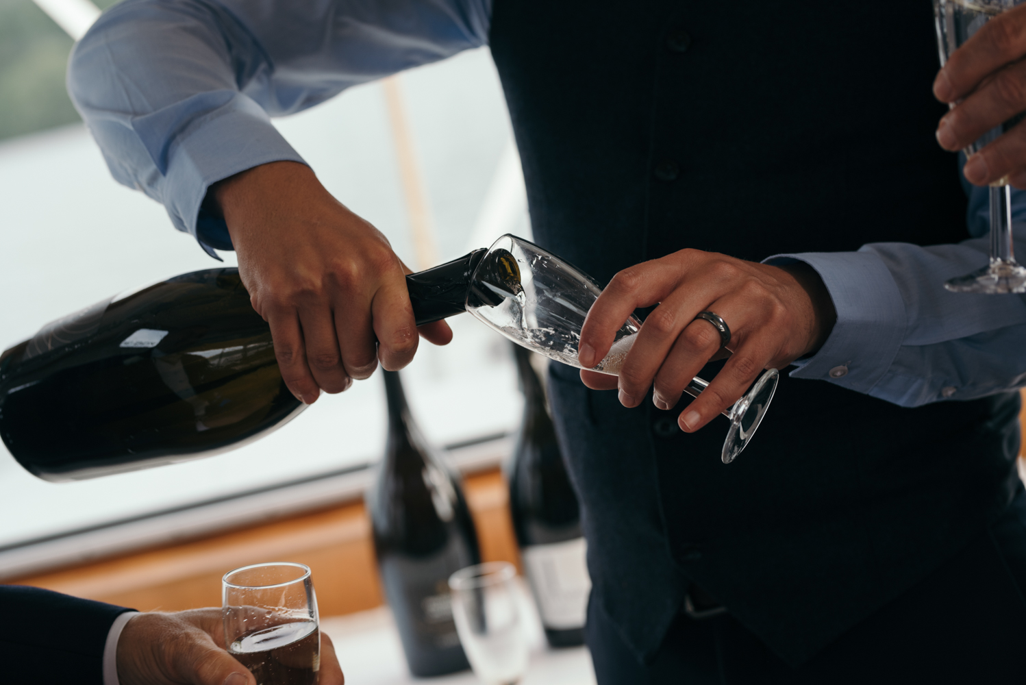 Photo of a guest topping up the glasses with Prosecco during the lake cruise